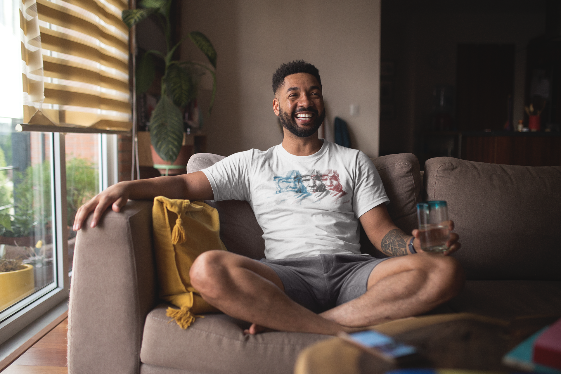 t-shirt-mockup-of-a-smiling-man-with-an-arm-tattoo-relaxing-at-home-21345.png