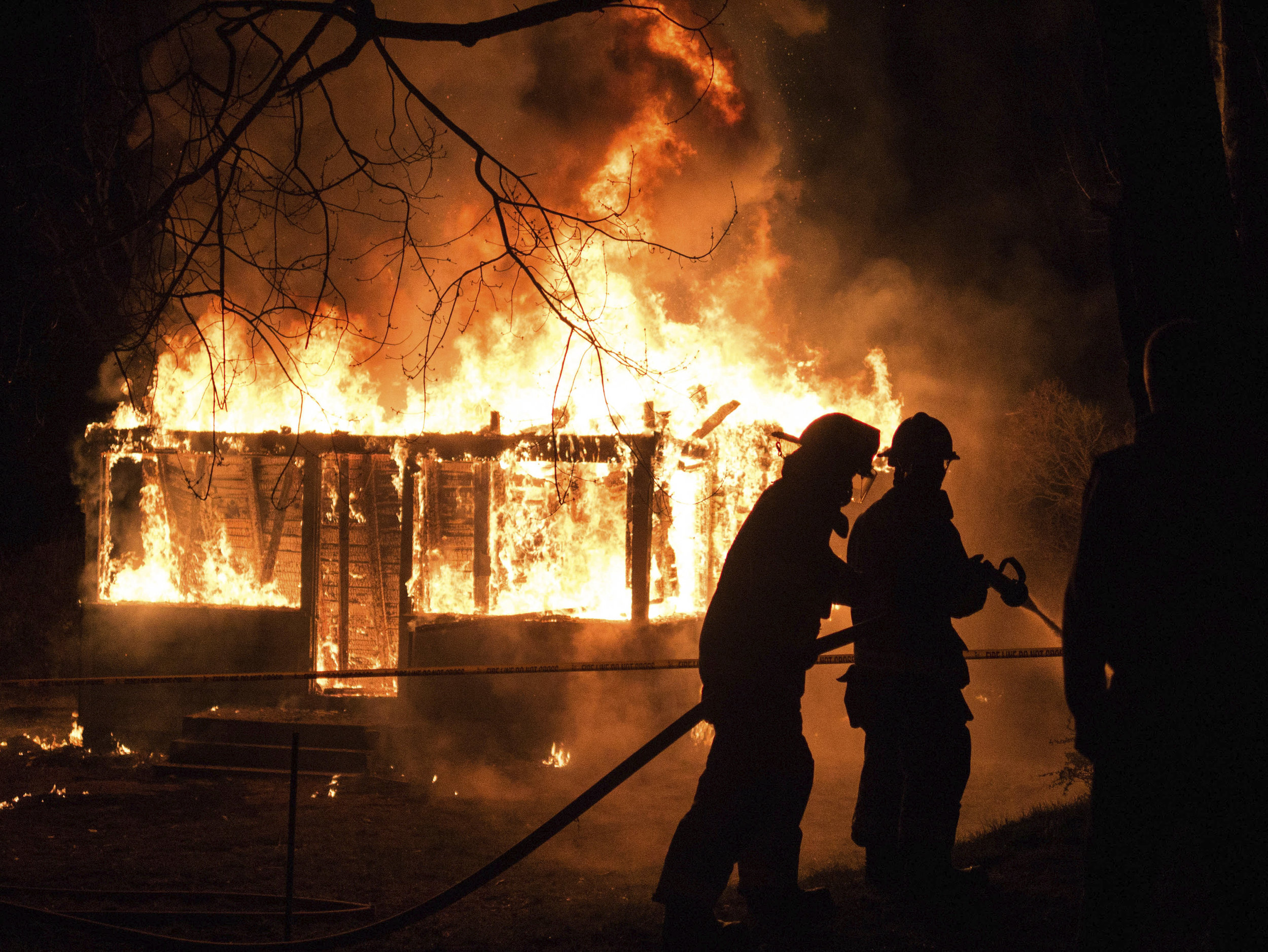 Camden firefighters keep the controlled burn of the abandoned house in check. Photo by Peter Kalajian