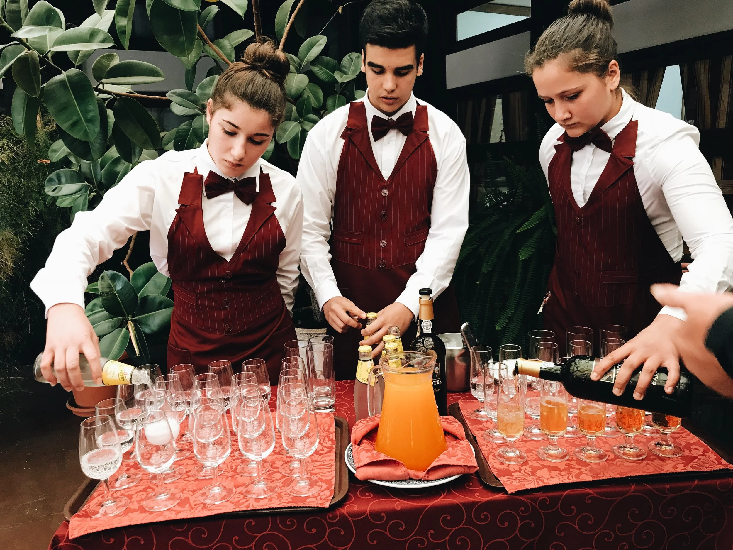 Hotel management students serve drinks for attendees