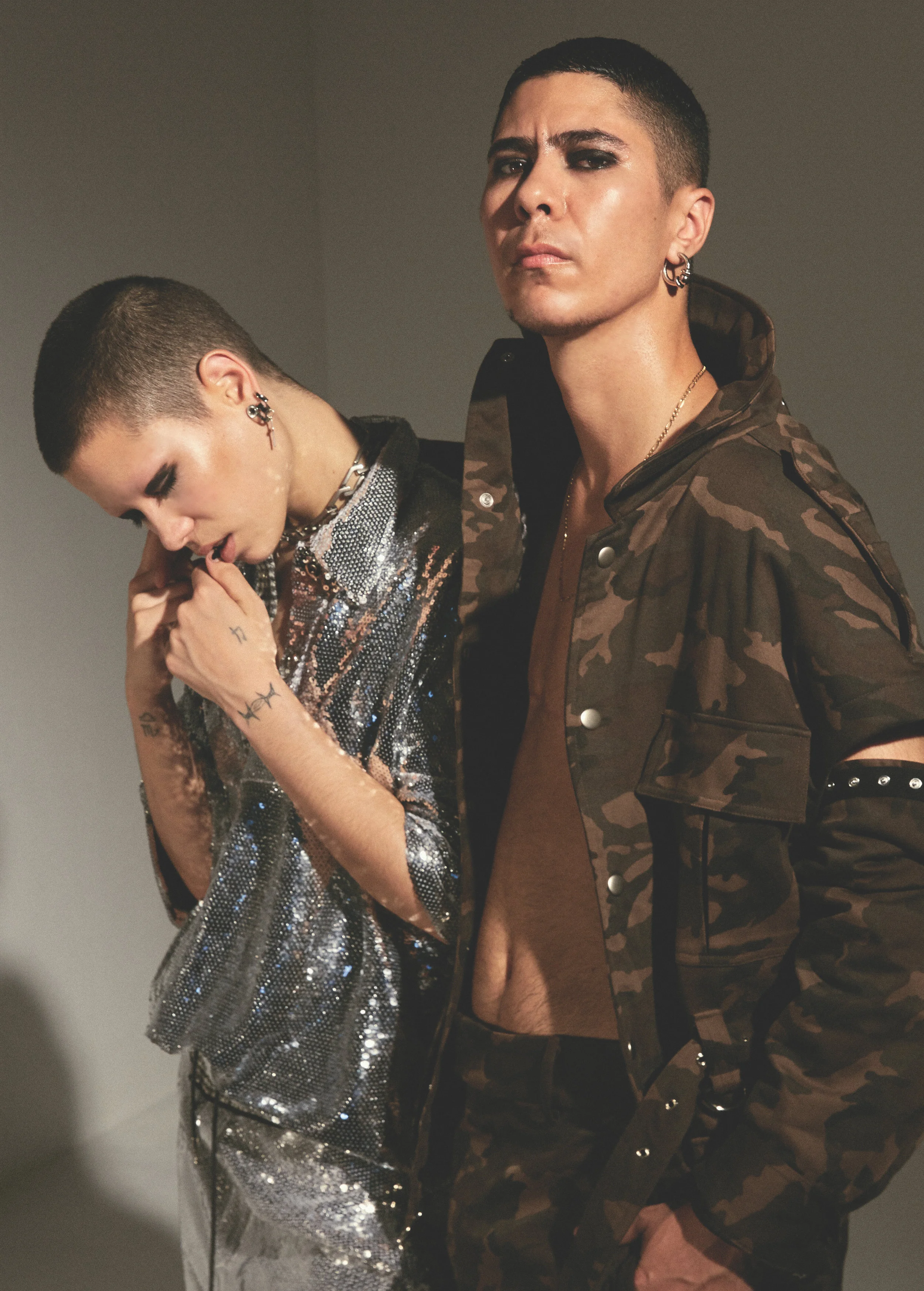 On Cheeky— Private Policy Silver Sequin Polo and Sequin Pant, Model’s own Jewelry, On Nad— Private Policy Green Camouflage Jacket with Detachable Sleeves and Pant with Open Knees, Model’s own Jewelry