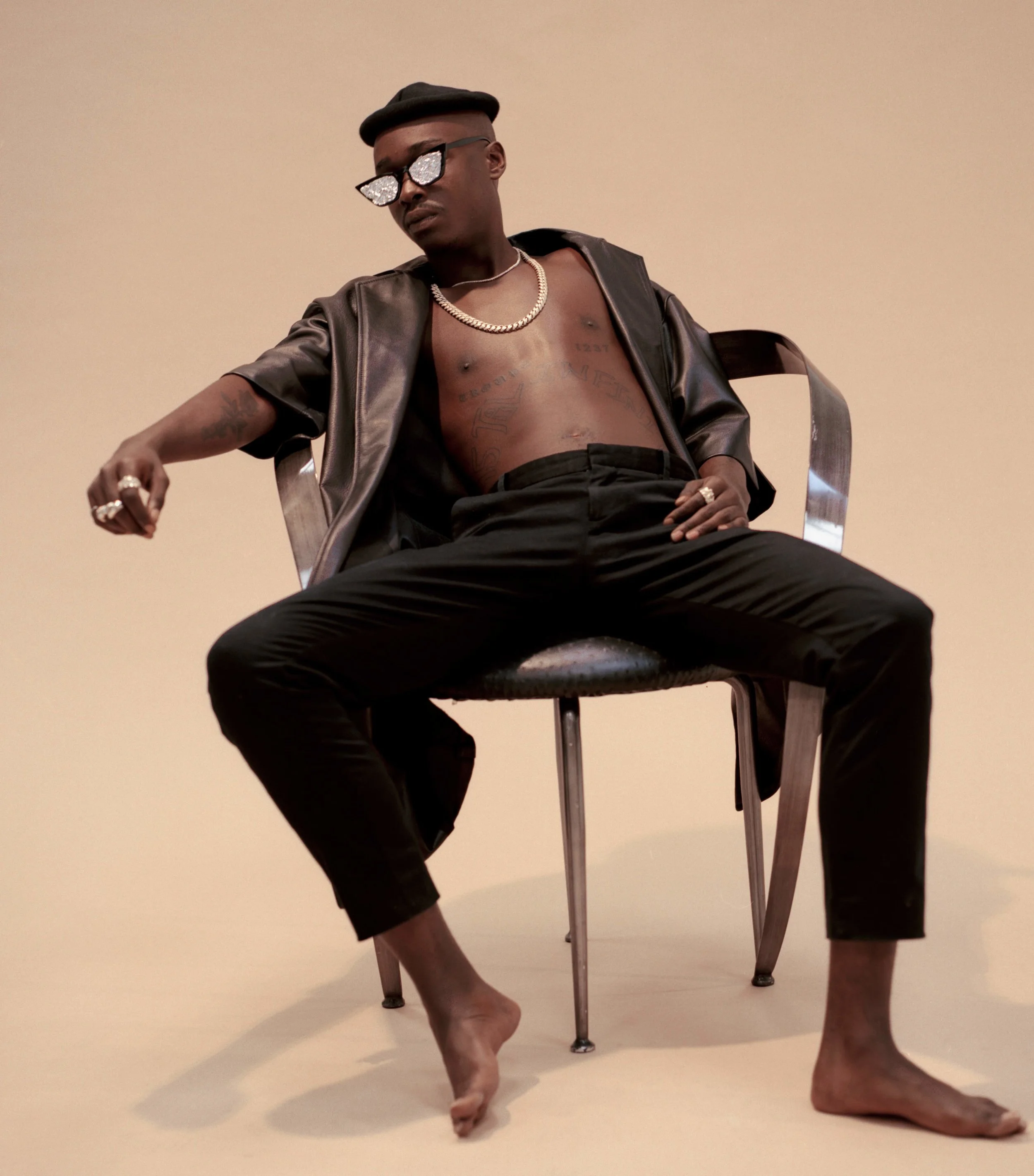 Fear of God leather coat, COS Trousers, Ashton’s own glasses and hat, All jewelry by XIV Karats