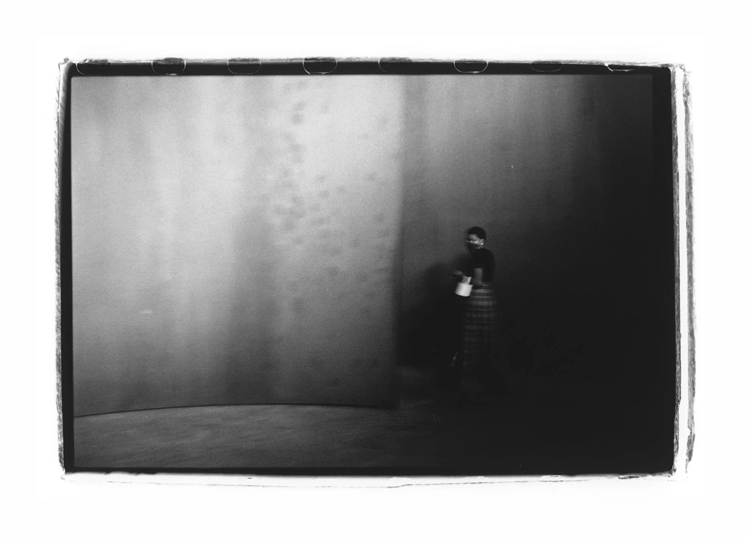 Black and white photograph of a woman next to a sculpture