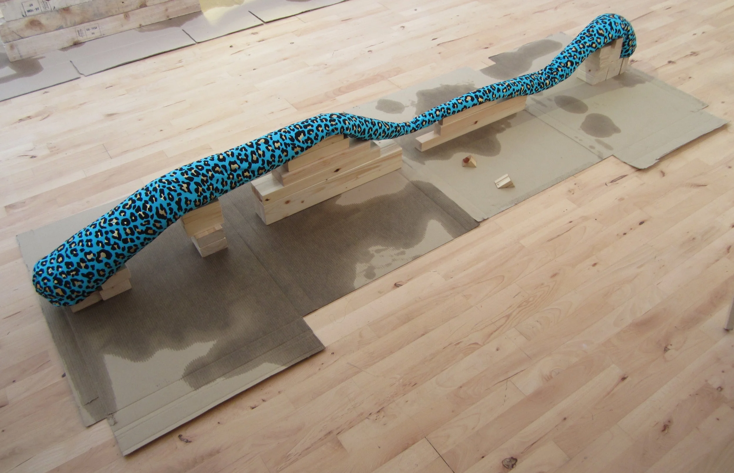 (Leopard Flump Supported) In Ecstasy - blue leopard print spandex, stuffed and weighted, supported by waxed and polished wood on oil and cardboard, 2014