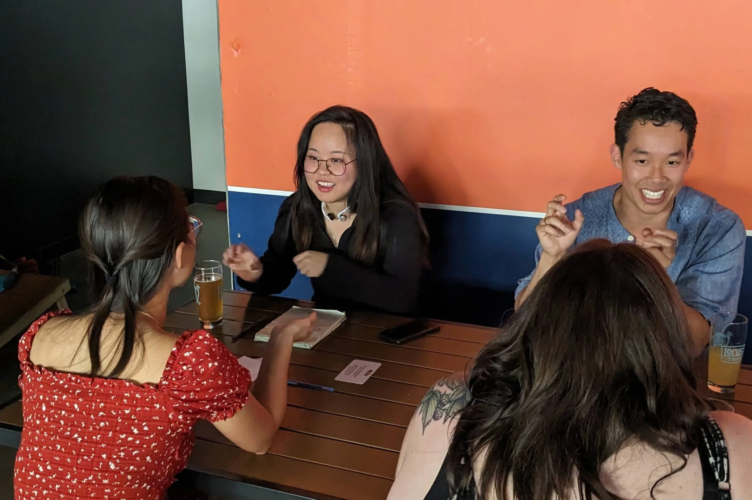 Four strangers talking in one-on-one conversations at a local Skip the Small Talk event.