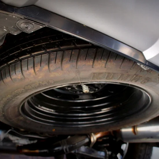 This tire is tucked beneath the car.