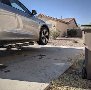 Car hood open during automotive repair in a residential driveway.