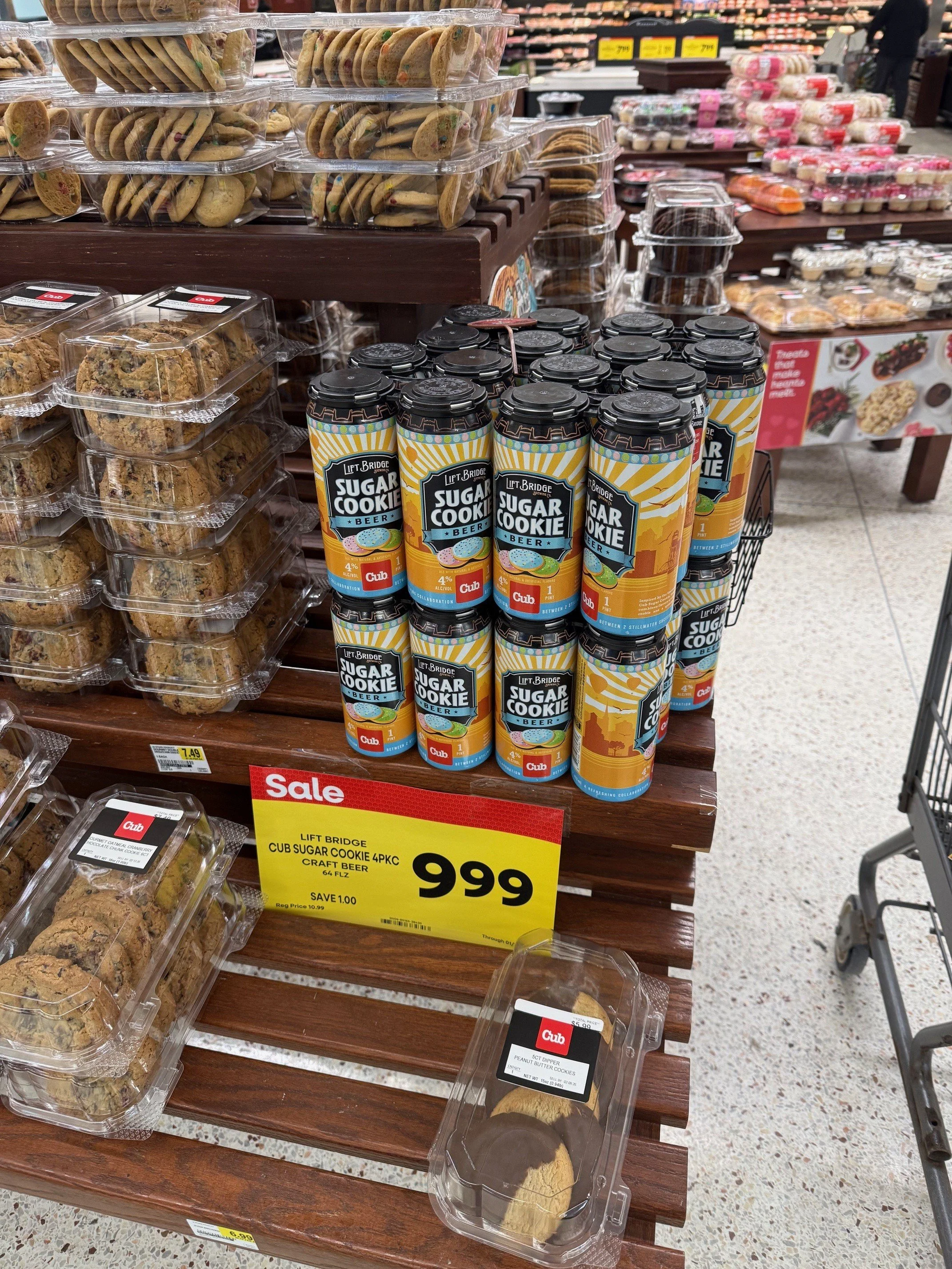 Display of packaged baked goods including cookies and craft beer in a grocery store aisle.