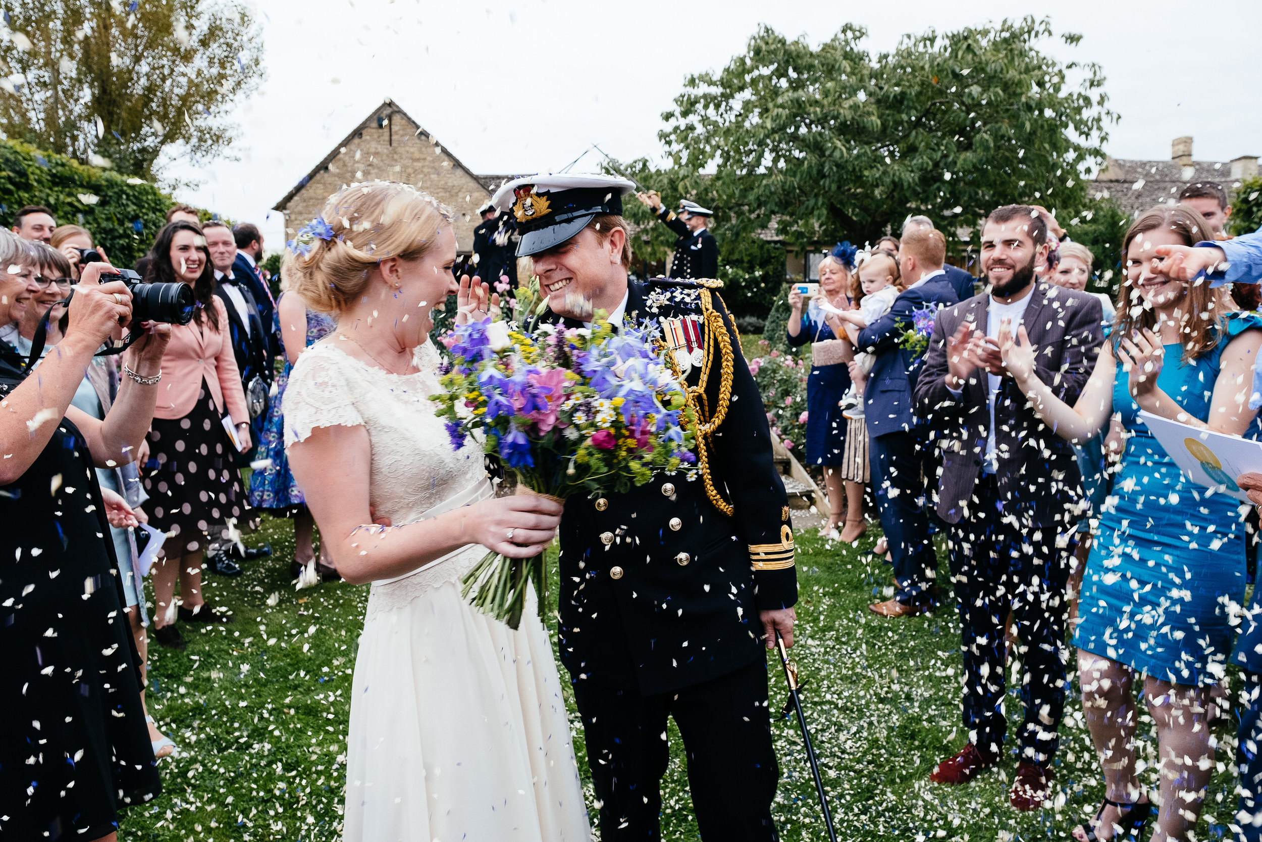A bride and groom get covered in confetti at Merriscourt Wedding Venue, Oxfordshire