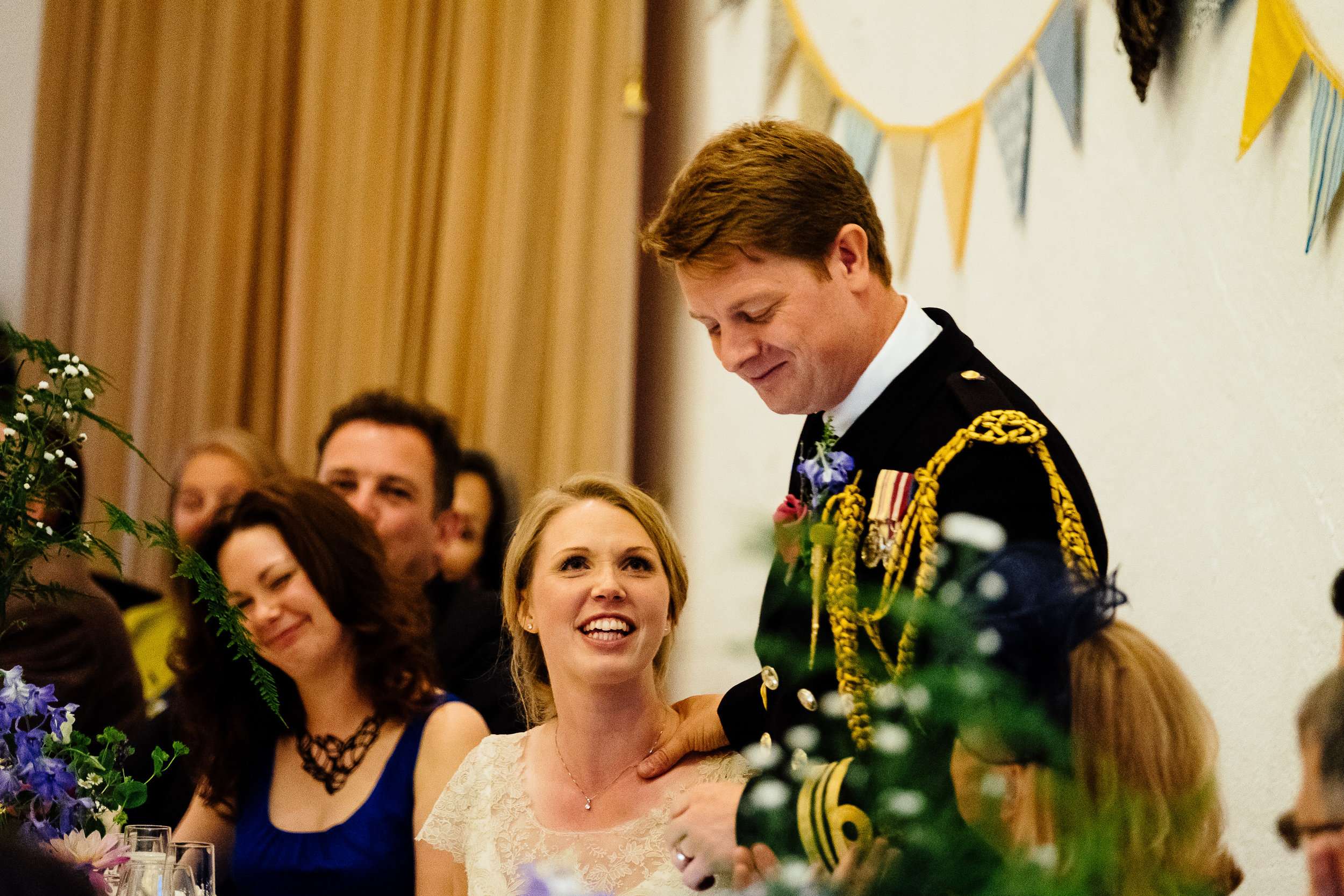 A bride listens to her groom giving a speech at Merriscourt Wedding Venue, Oxfordshire