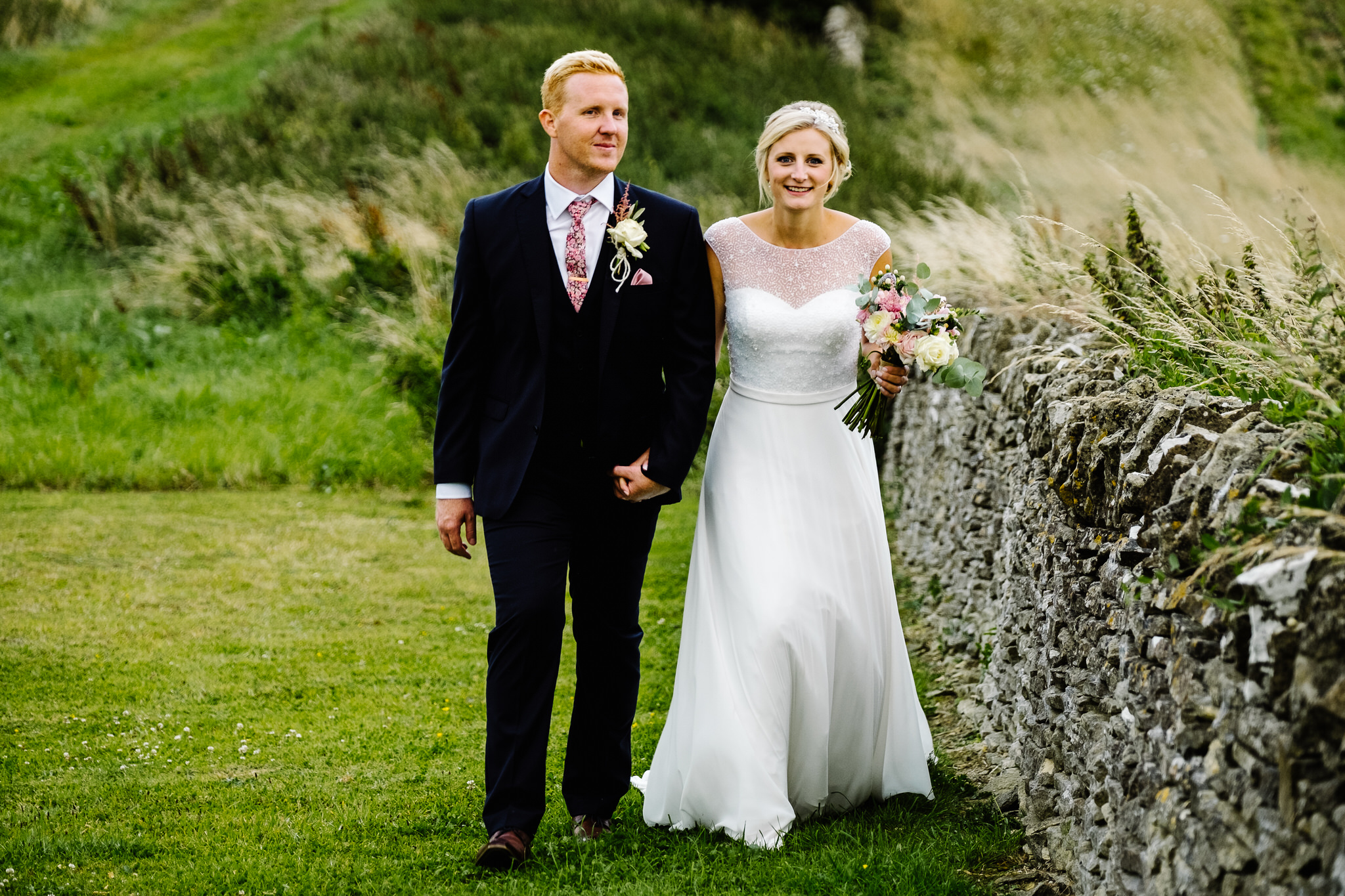 A bride and groom walking outside their wedding venue, Cripps Stone Barn , Gloucestershire