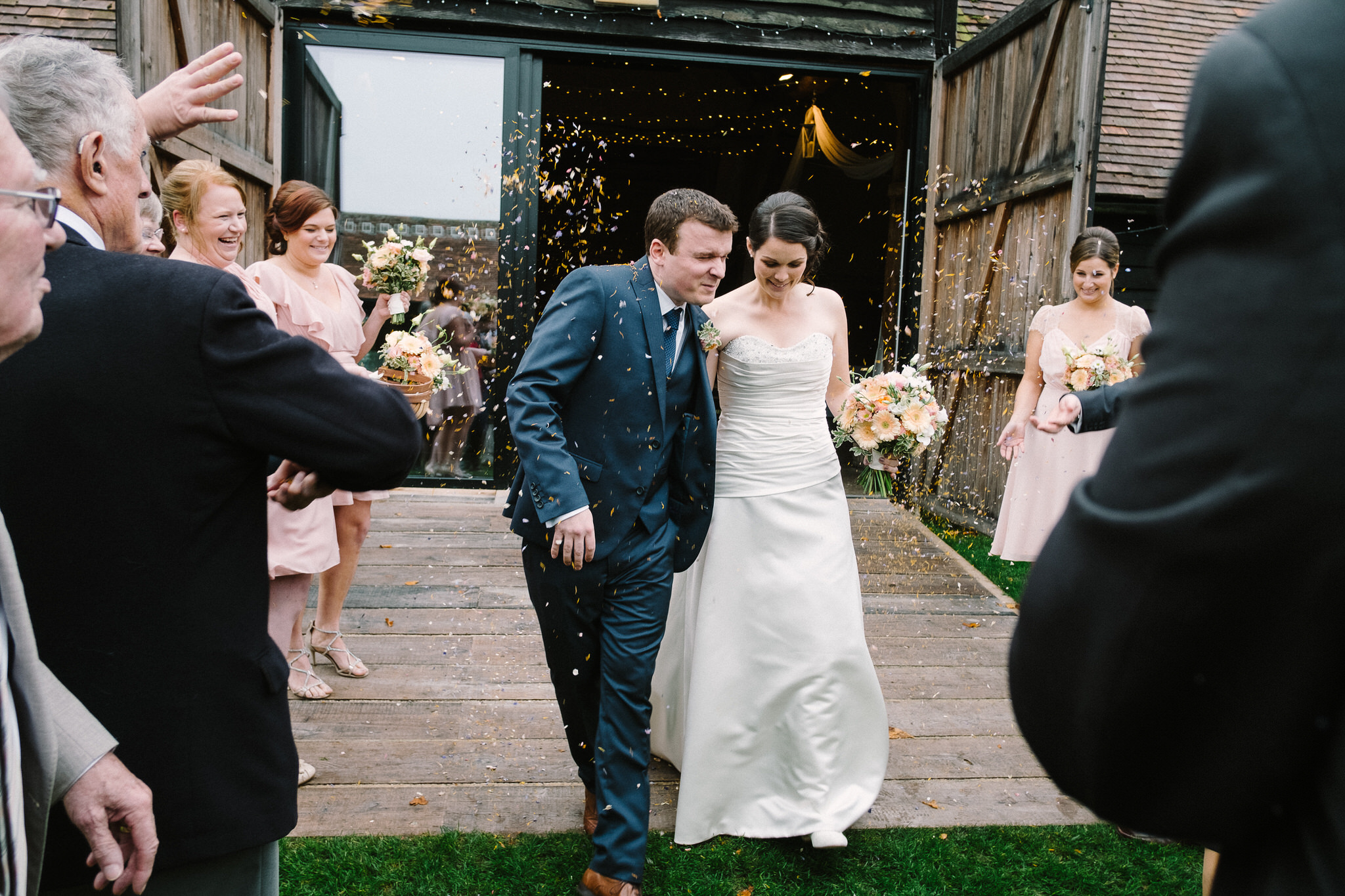 A bride and groom leaving their wedding ceremony at Lains Barn, Wantage, Oxfordshire