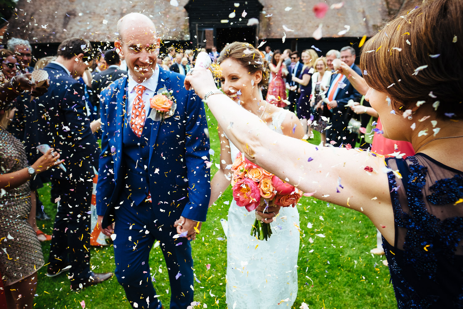 Lains Barn wedding photograph showing a bride and groom being showered in confetti