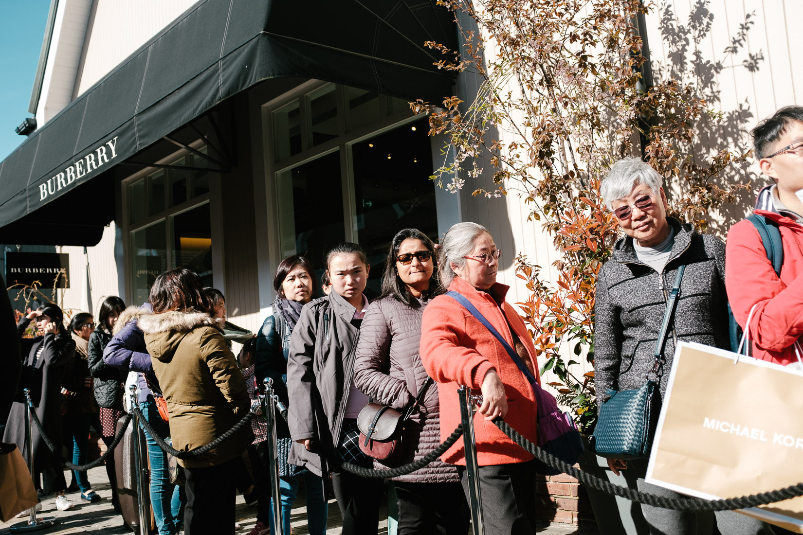 Shoppers queuing outside the Burberry Store at Bicester Village outlet centre