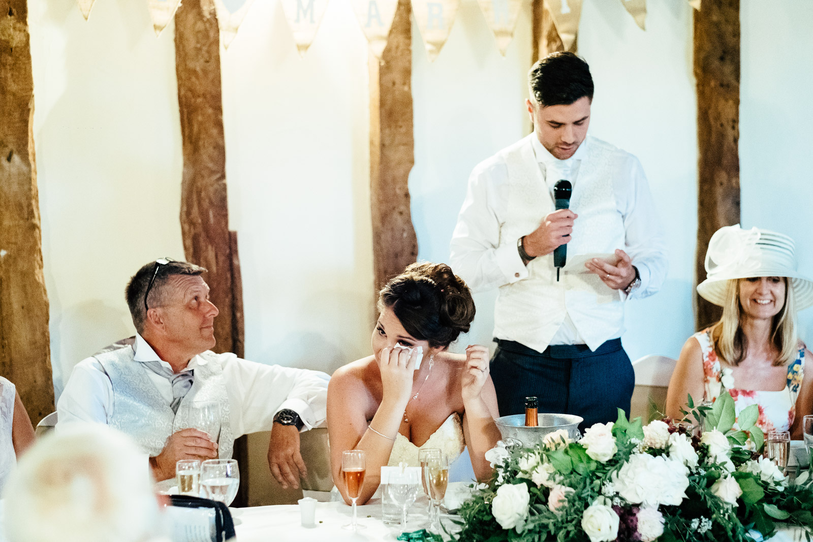 A bride wipes away a tear at Notley Tythe Barn Wedding Venue