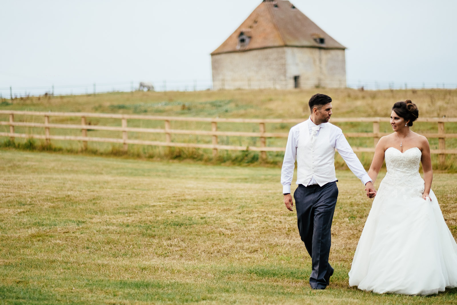 A bride and groom walking outside Notley Tythe Barn wedding Venue