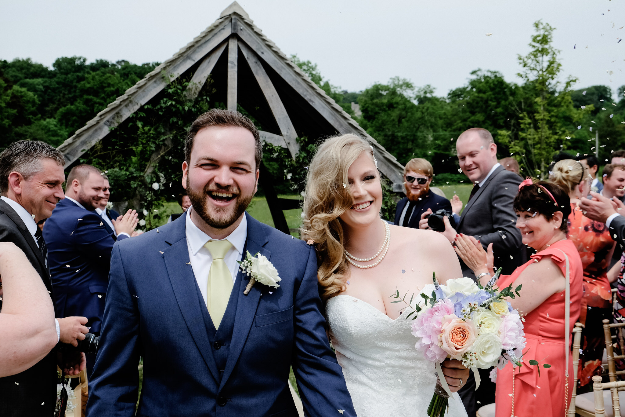 Bride and Groom covered in confetti during their wedding at Hyde Barn, Stow on the Wold