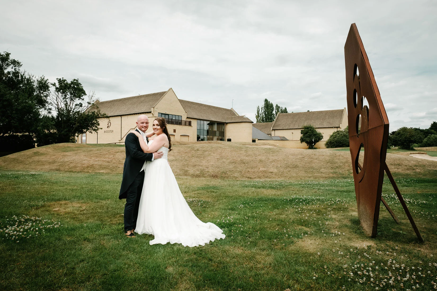 A bride and groom outside their wedding venue, Bicester Hotel, Golf and Spa