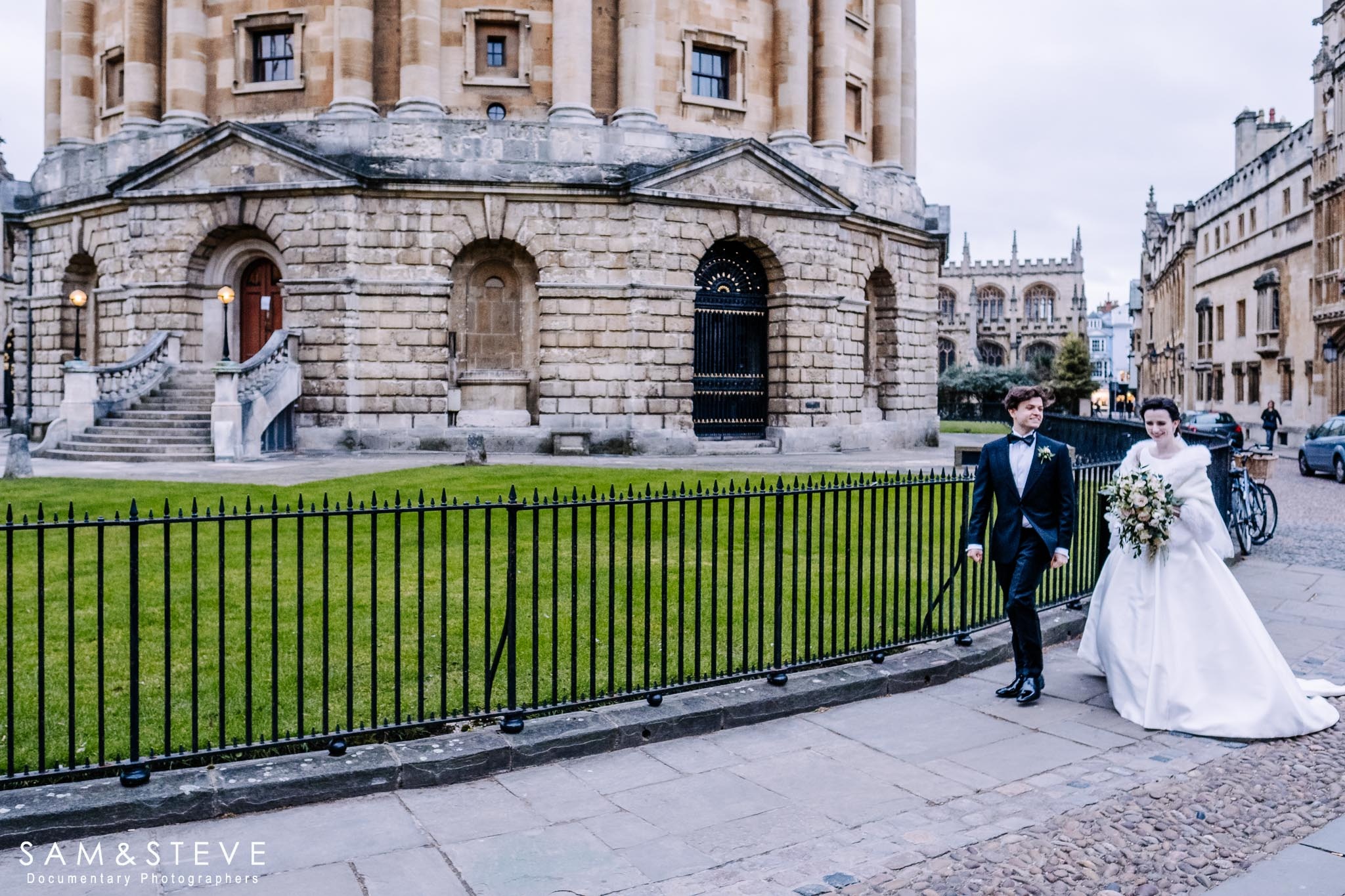 a bride and groom walking by the Radcliffe Camera, Oxford