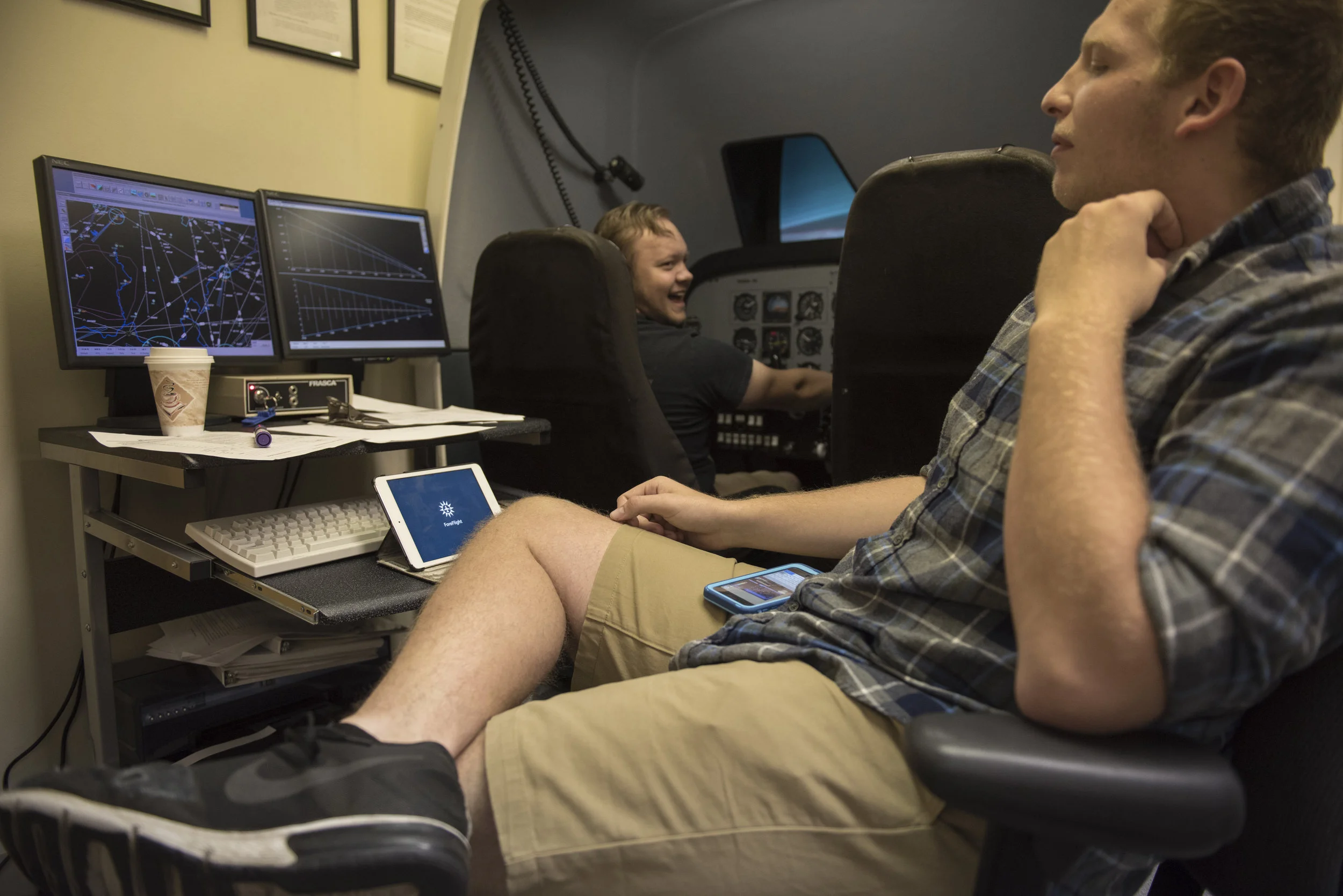 Flight instructor Michael Popo (right) instructs Ohio University sophomore Jacob O'Dea in the simulator on Sept. 23, 2017. Popo and O'Dea spent five hours in the simulator getting caught up on lessons.