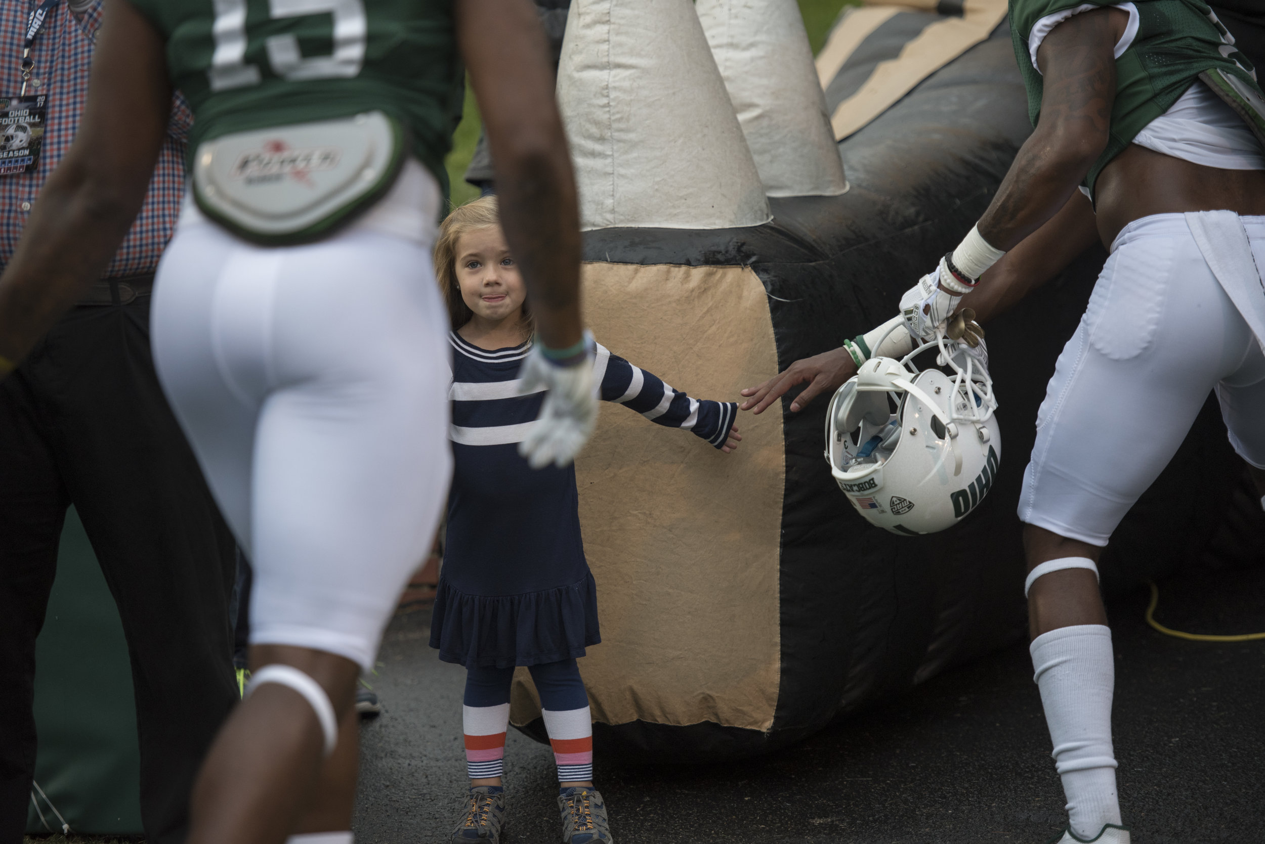 Penelope Carroll, age 4, high fives Ohio University football players as they go back into the tunnel on Sept. 2, 2017 during the home football game against Hampton University. 