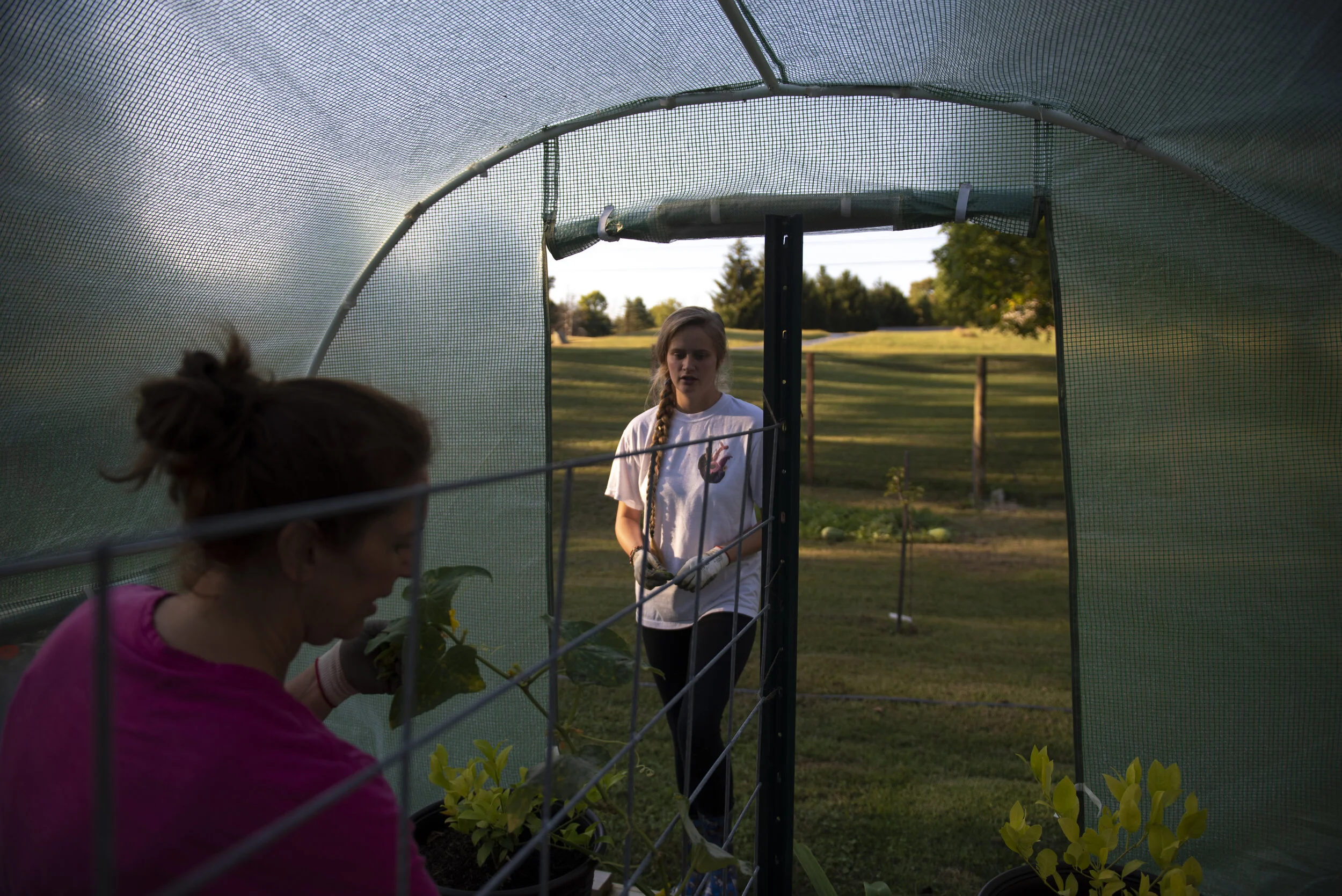   Marlene and Jess work inside the greenhouse on the Poches’ property. The greenhouse houses some of the plants that need more attention and less light.  