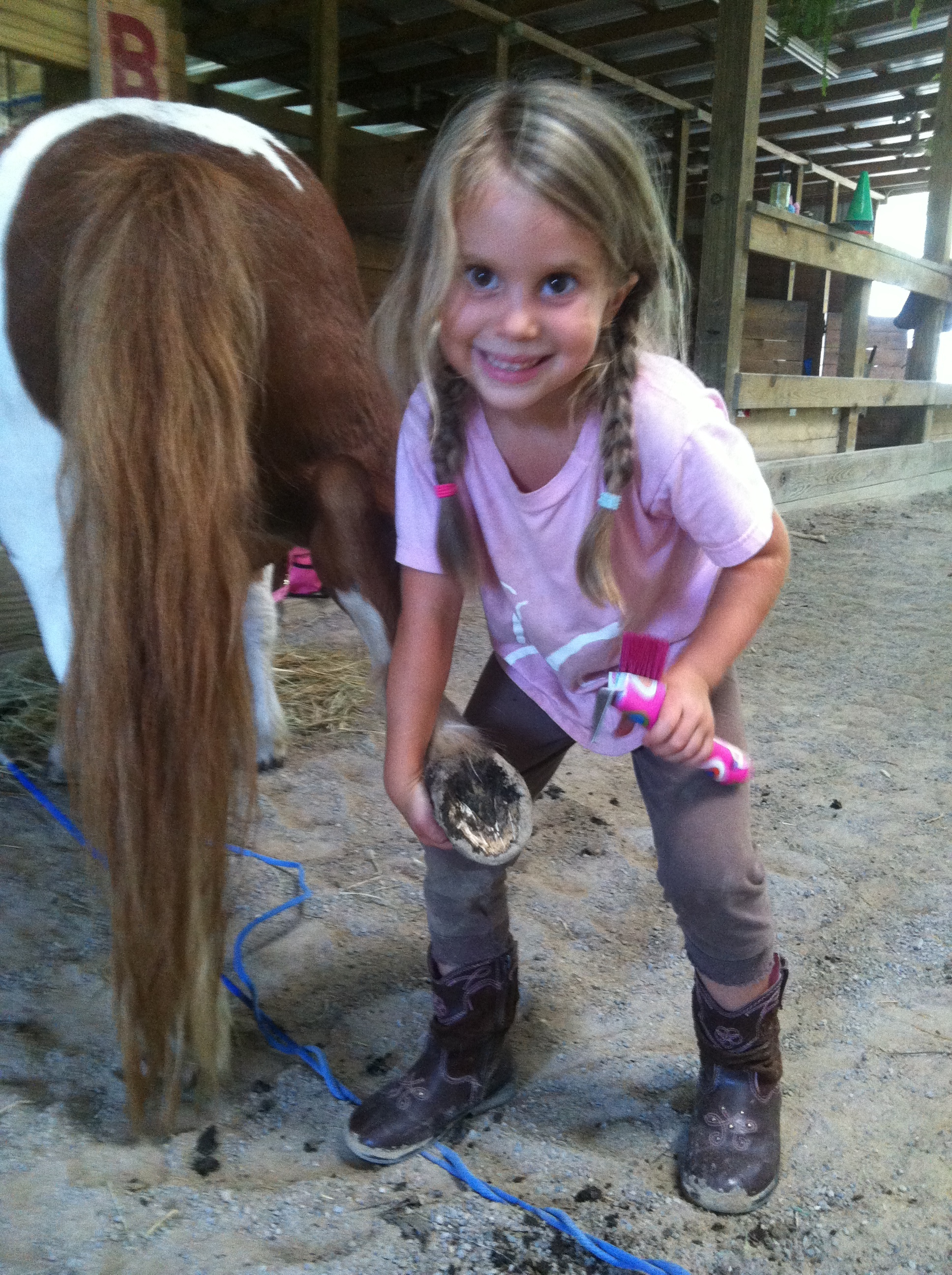 Even the little ones learn how to clean their horse's hooves!