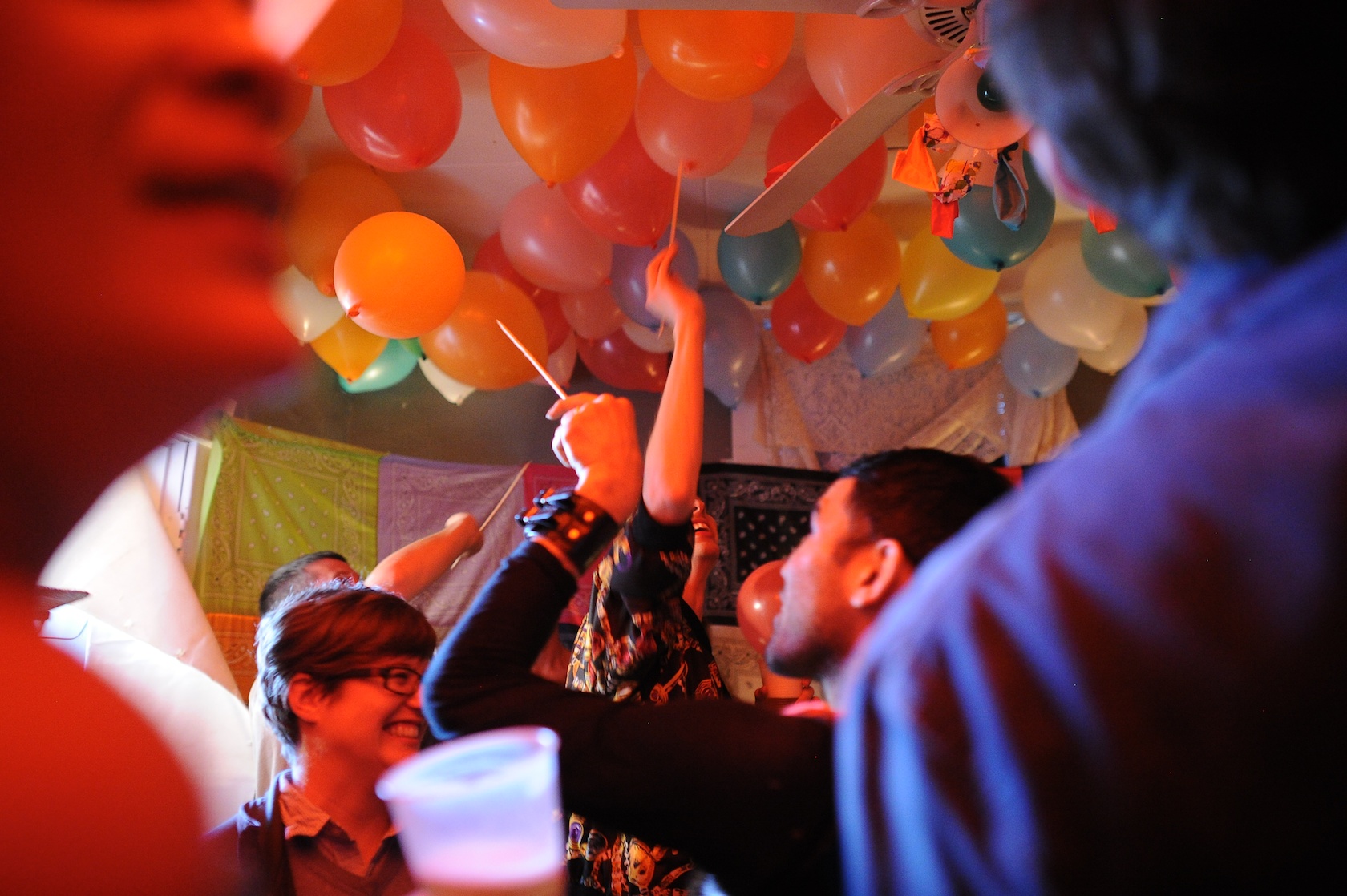 Participants pop balloons with skewers taken from a drag queen's headpiece, on which were all the components of Chicago hot dogs. They are looking for clues to find the secret door to the next room.