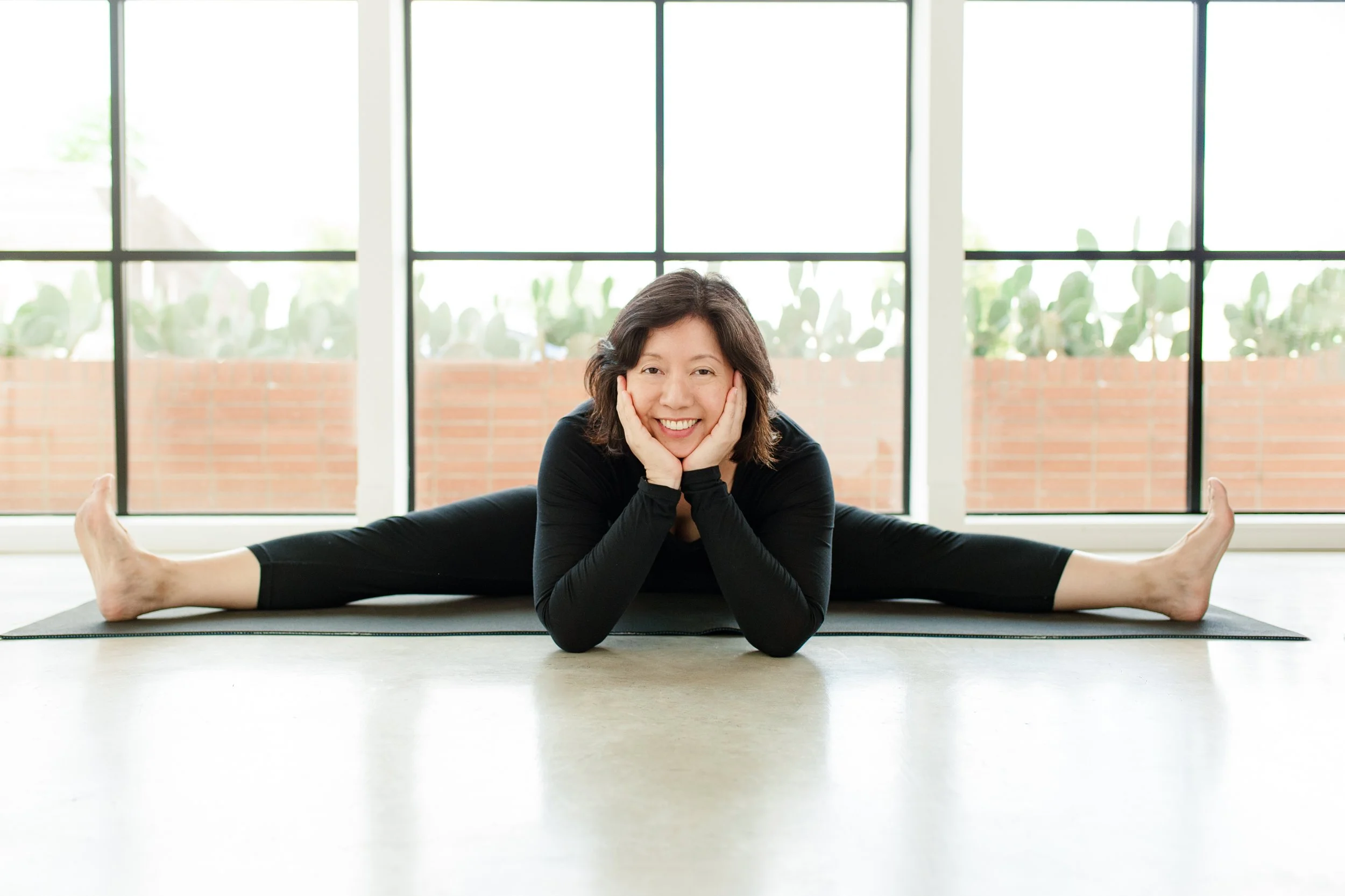 Dr Lynn Chang of Career Zen in yoga pose stretching and smiling