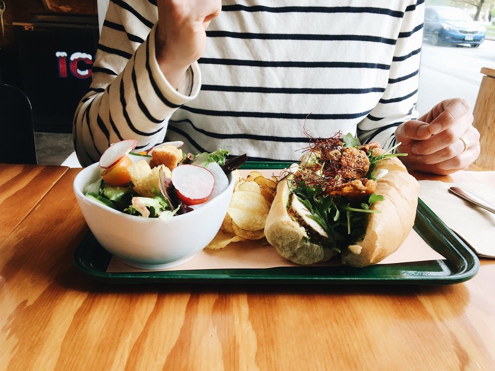 Enjoying a chicken sandwich at the Tuck Shop in Vancouver