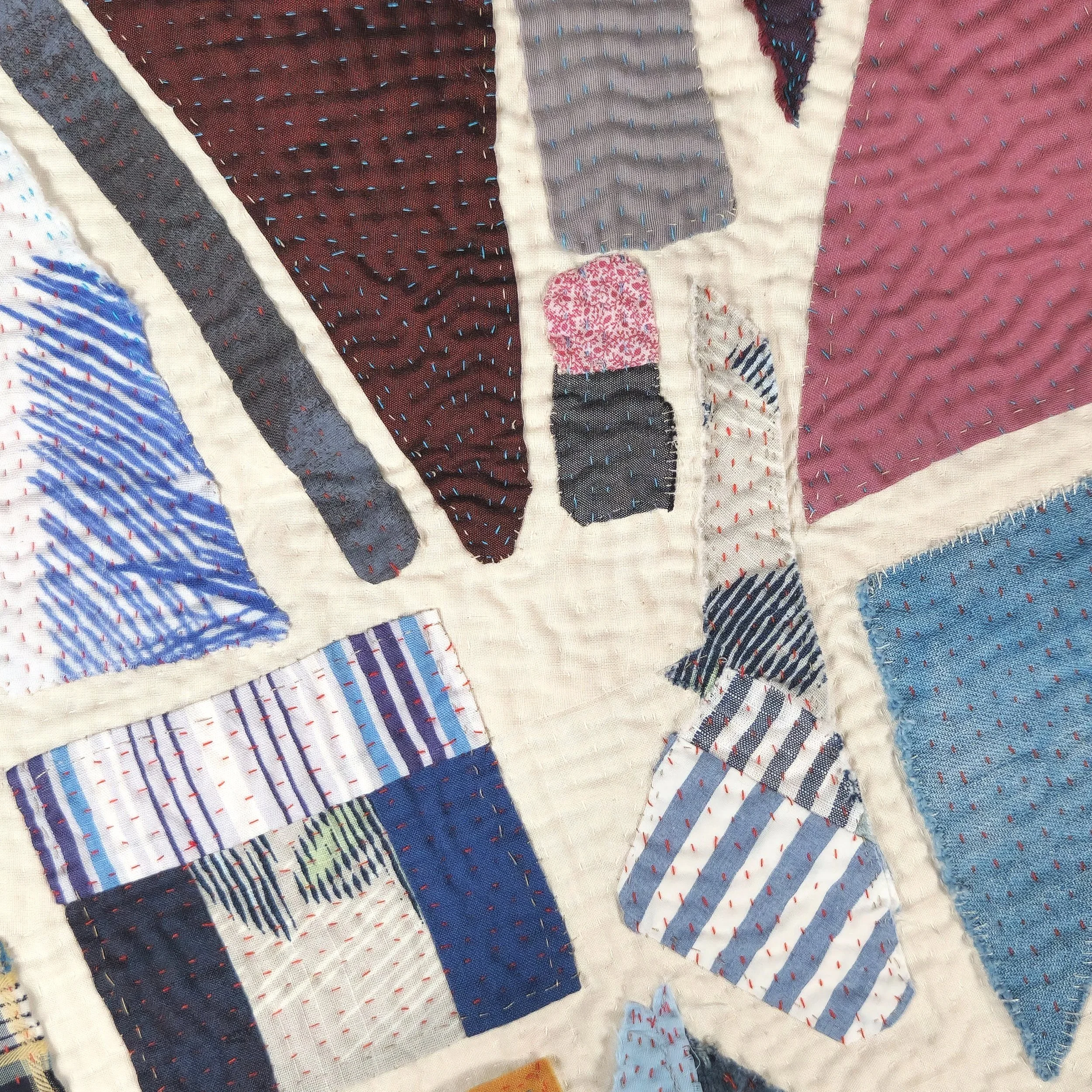 Detail view of Meet Me at the Corner. Reclaimed garments and other cotton fabrics, hand pieced and quilted. 25.5x28 inches, 2025