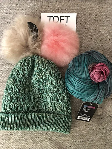 Elizalit weighs pompom options for her hat (knit in the Seaglass shade of Vivacious DK ) and considers yarn for a matching Bramen Cowl .
