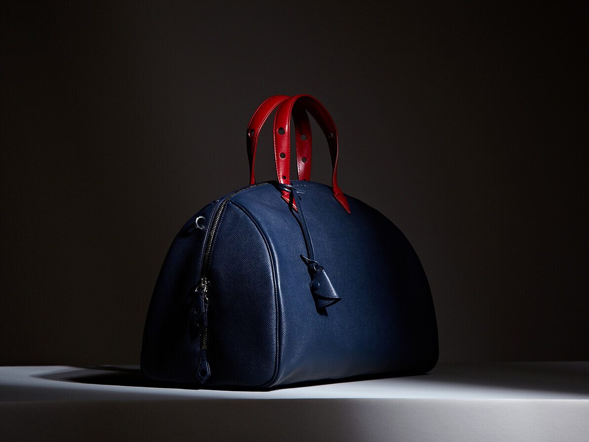 Myriam Schaefer leather bag. Blue with red handles. Product shot.
