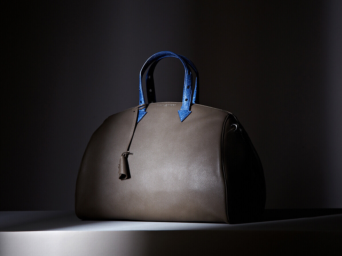 Myriam Schaefer leather bag. Beige with bliue handles. Product shot.