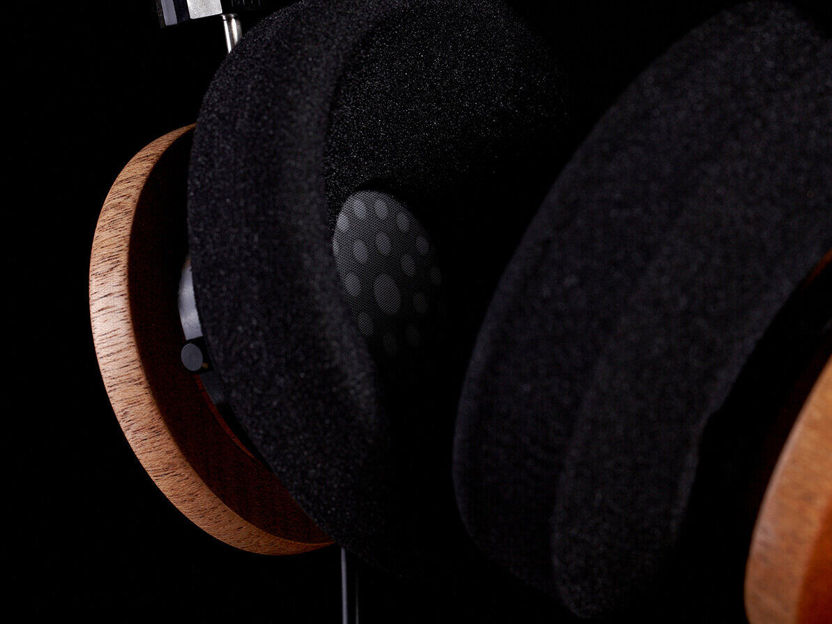 Close up wooden and foam headphones. Black background.