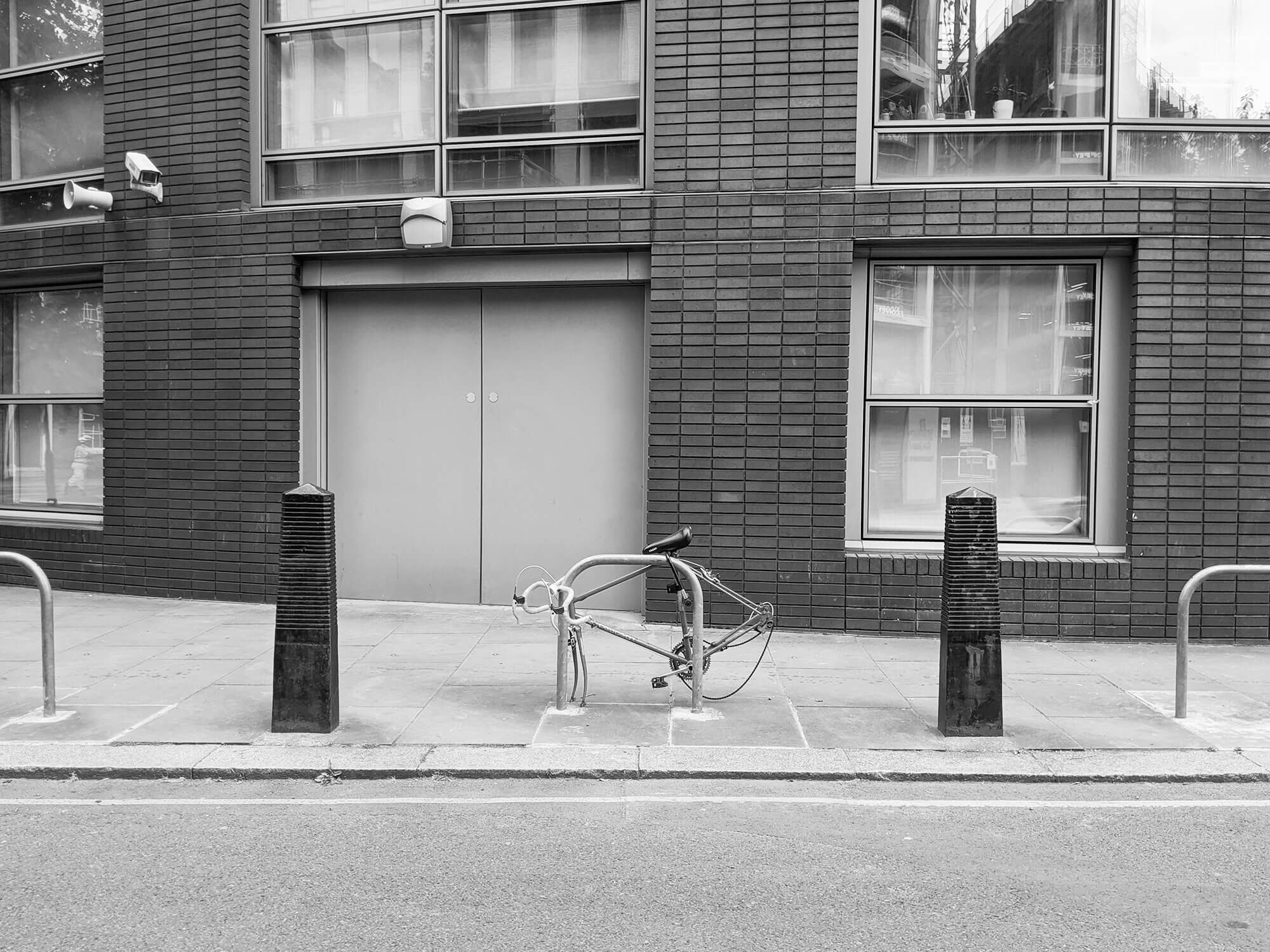 Discarded bike in London city. Bike missing wheels.
