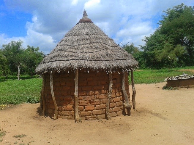 A home constructed of local bricks and a thatched roof.