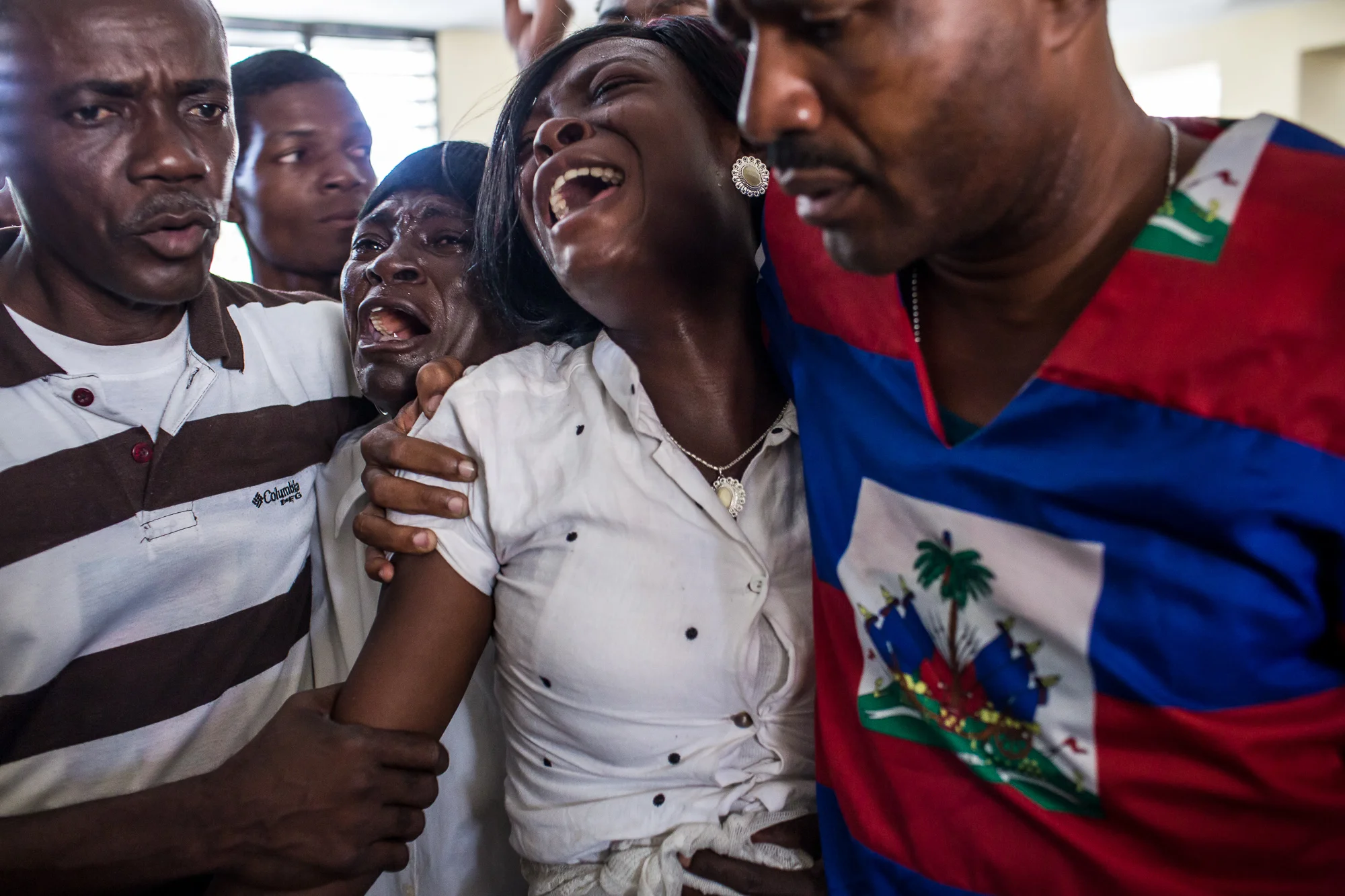 Claudiani Fonrose, third from left, and Bertha Nicolas, 20, second from right, grieve at the funeral of Jolin Nicolas, 19, on Monday, December 22, 2014 in Port-au-Prince, Haiti. Jolin Nicolas, their son and brother, respectively, was killed by police while participating in anti-government protests on December 13.