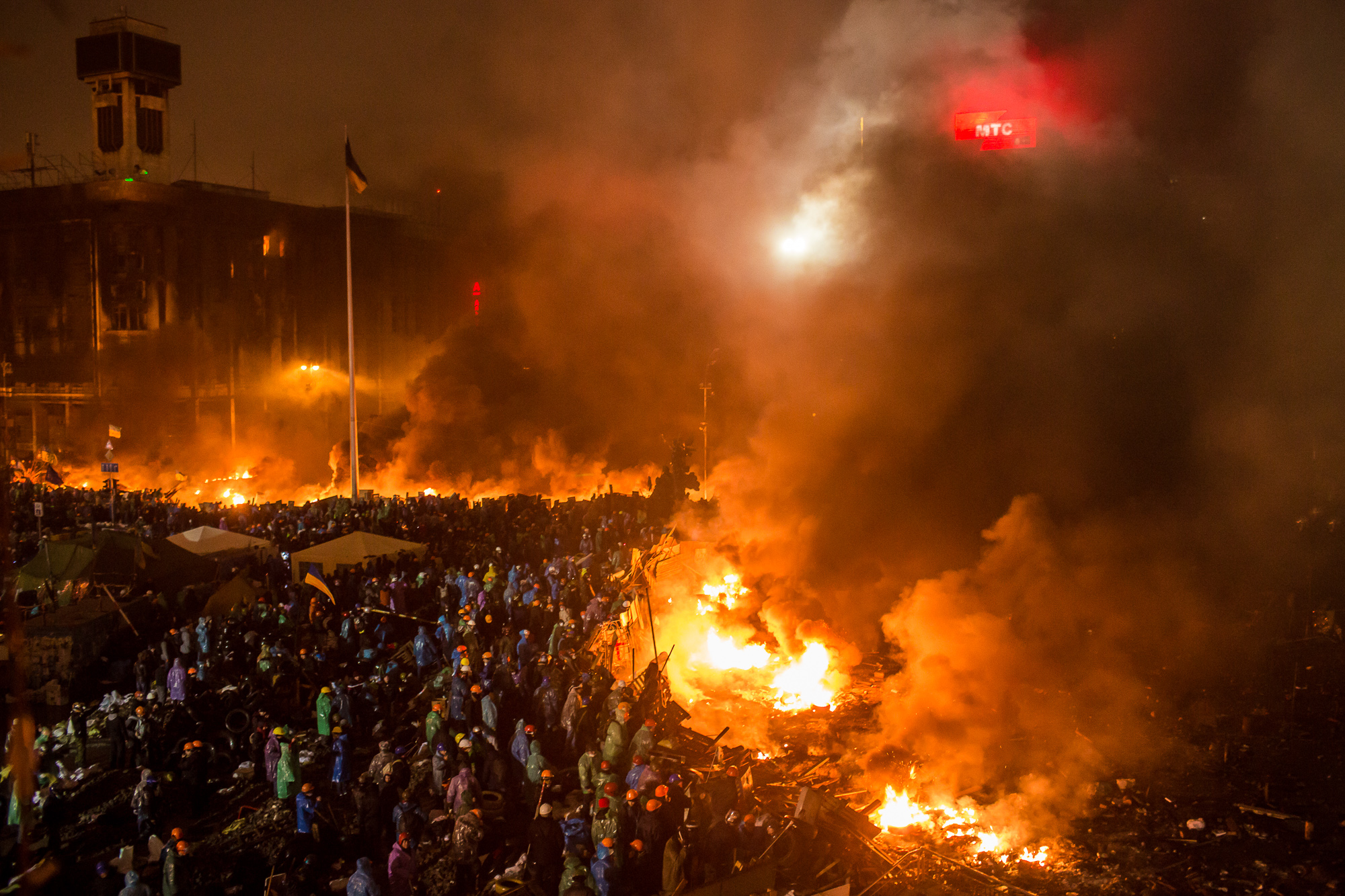  Anti-government protesters stand behind a line of burning tires and debris on Independence Square on February 19, 2014 in Kiev, Ukraine. After several weeks of calm, violence has again flared between anti-government protesters and police as the Ukra