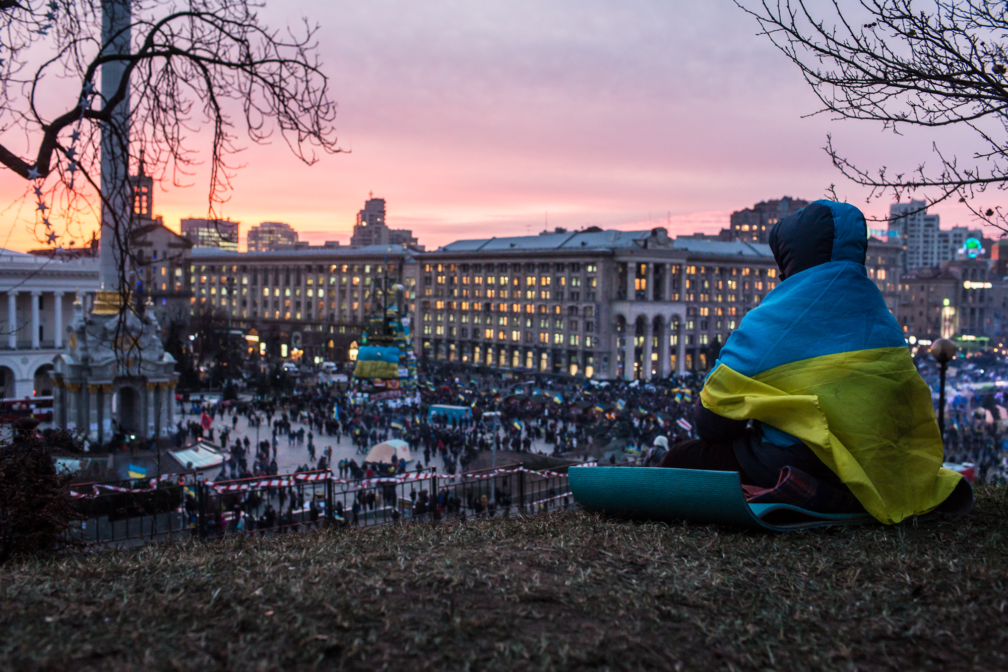  A person wrapped in a Ukrainian flag watches the sun set over Independence Square on December 4, 2013 in Kiev, Ukraine. Thousands of people have been protesting against the government since a decision by Ukrainian president Viktor Yanukovych to susp