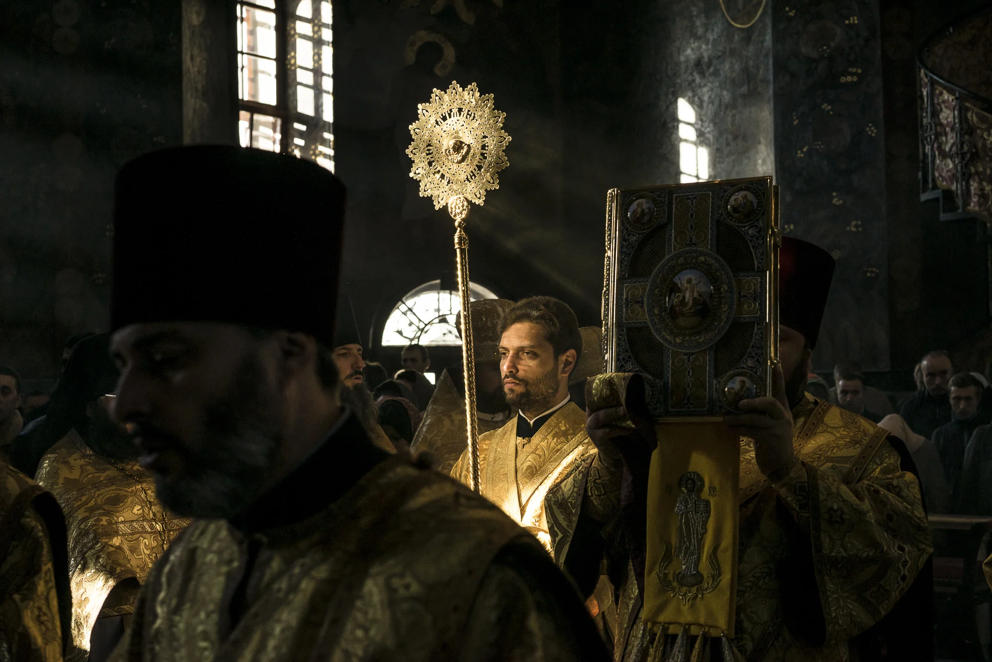 A deacon carries a fan as another holds aloft a copy of the holy gospel during Sunday liturgy services at the Refectory Church of Sts. Anthony and Theodosius at the Pechersk Lavra on Sunday, October 7, 2018 in Kyiv, Ukraine.