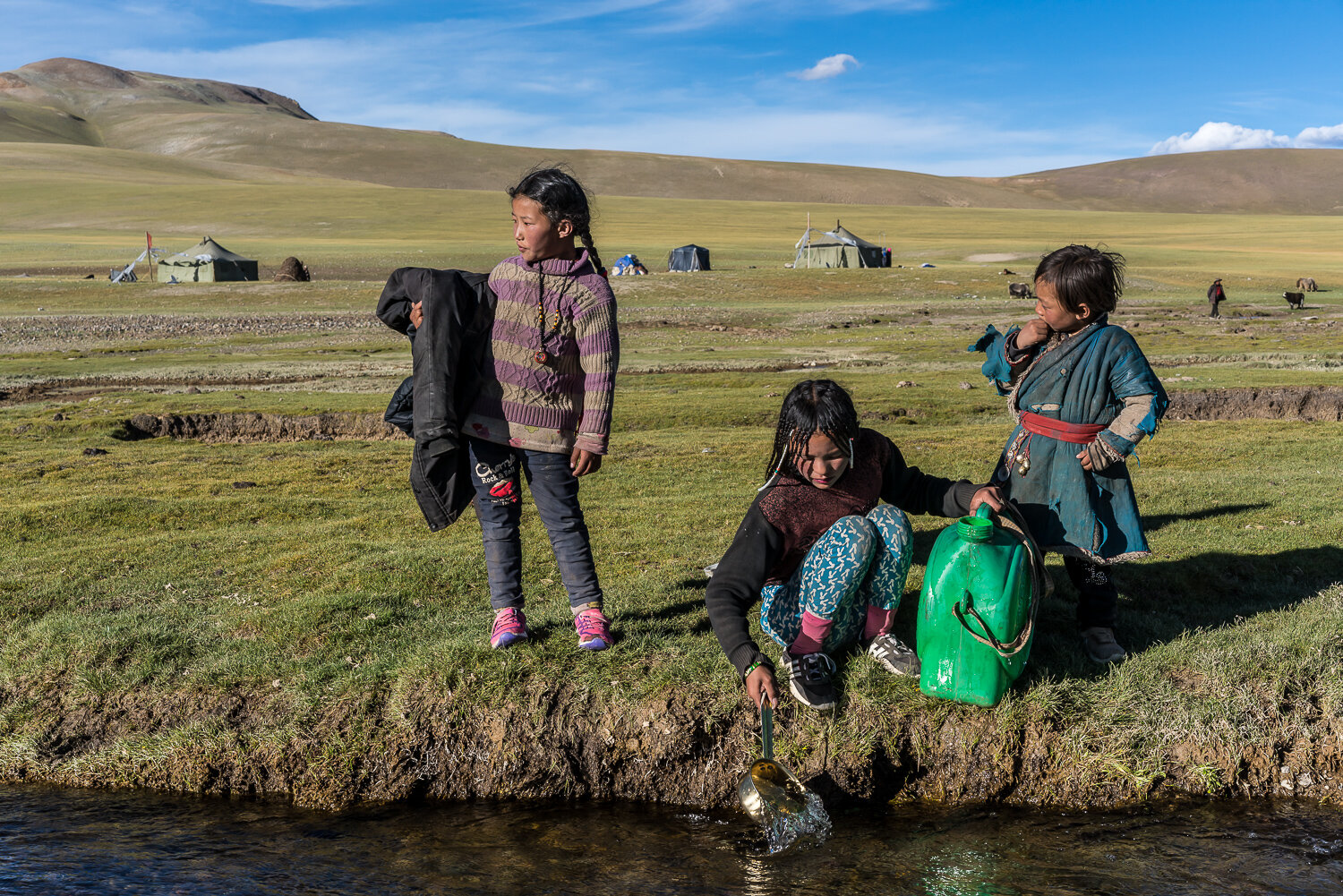  Kalzang Tseden, 14, center, collects water from the Indus River as Yeshi Lhumu, 7, left, and Samnor, 5, right, watch near their nomad camp along the Indus River on Friday, September 6, 2019 in Gê'gyai County, Ngari Prefecture, Tibet, China. 