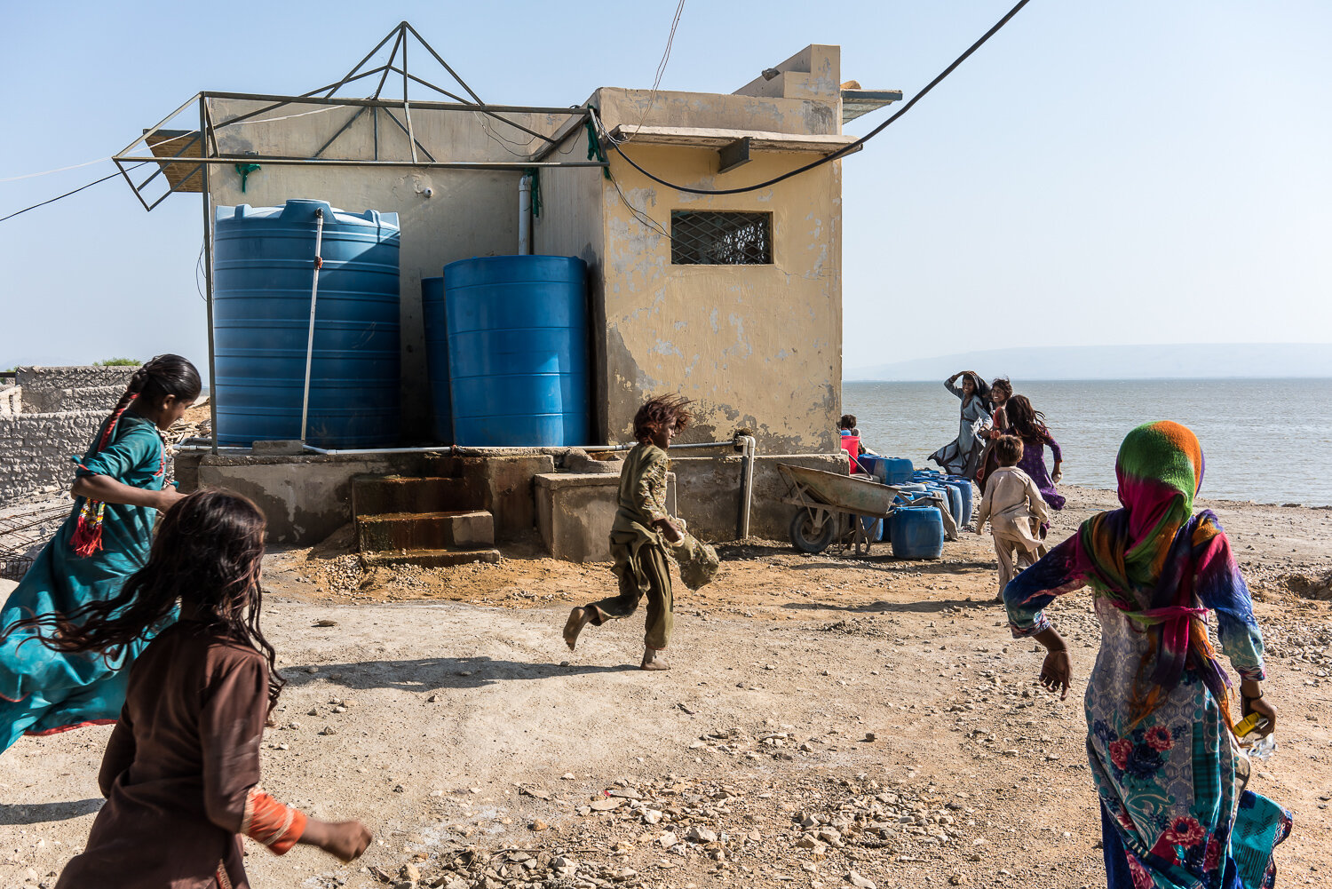  Children run to a reverse osmosis water filtration plant in anticipation it will turn on so they can draw water on Saturday, September 28, 2019 in Manchar, Sindh, Pakistan. Manchar is the largest freshwater lake in Pakistan, but its water has become