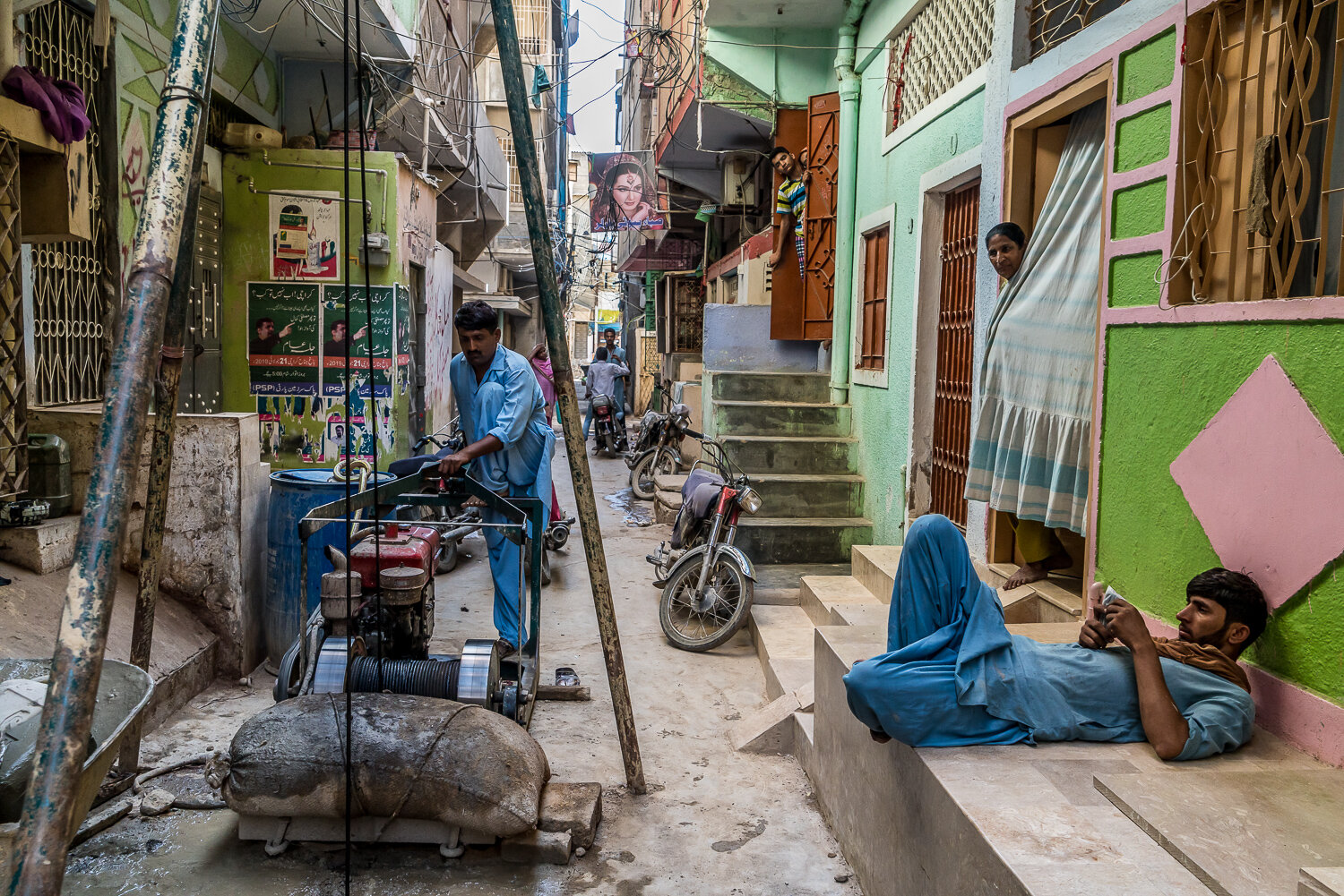  Salim Rahu, 29, left, drills a bore well to provide fresh water for residents of a house as his colleague Shabeer, 19, right, relaxes on Saturday, October 12, 2019 in Karachi, Sindh, Pakistan. A large portion of Karachi's water supply is siphoned of