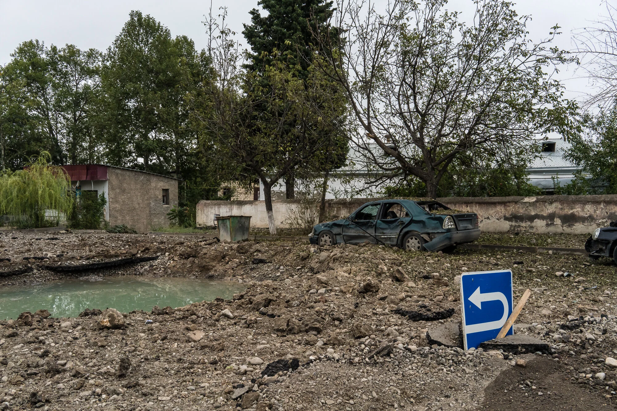 Destroyed cars and a crater in the road that are the result of a reported drone strike the previous day. Martakert, Nagorno-Karabakh. 2020.