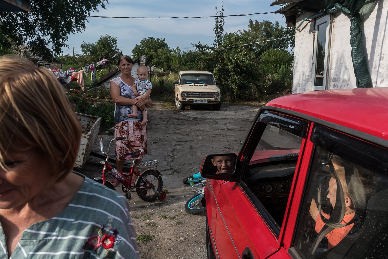  Natalia, left, a neighbor, visits a family with five children that managed to leave Russian-occupied territory by paying a smuggler $100 and now live in a rented house on Thursday, August 25, 2022 in Sokolivka, Ukraine. 