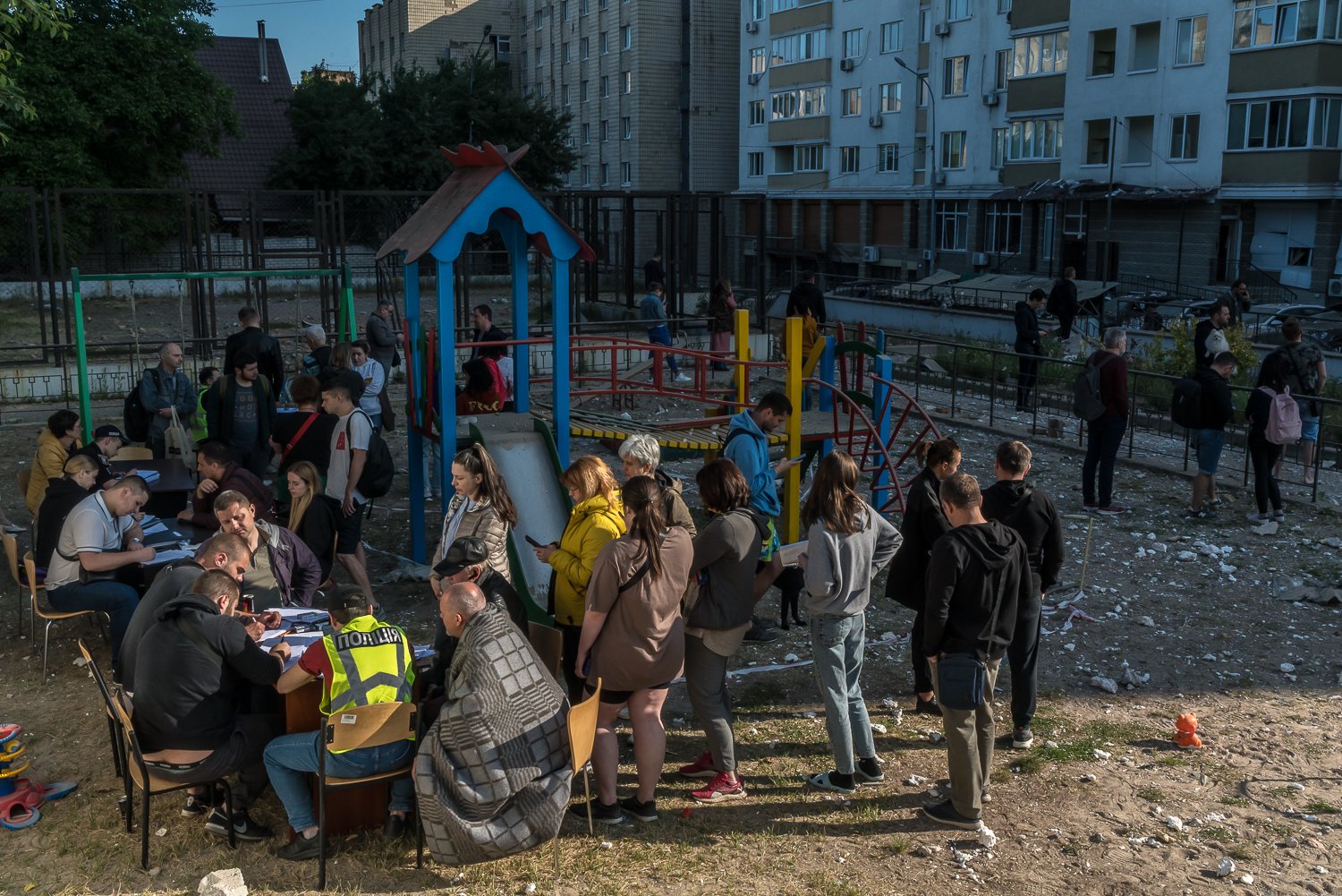  Residents of a high-rise apartment building that was damaged by debris from a Russian drone that was shot down during an overnight attack gather to fill out paperwork with the police on Tuesday, May 30, 2023 in Kyiv, Ukraine. 