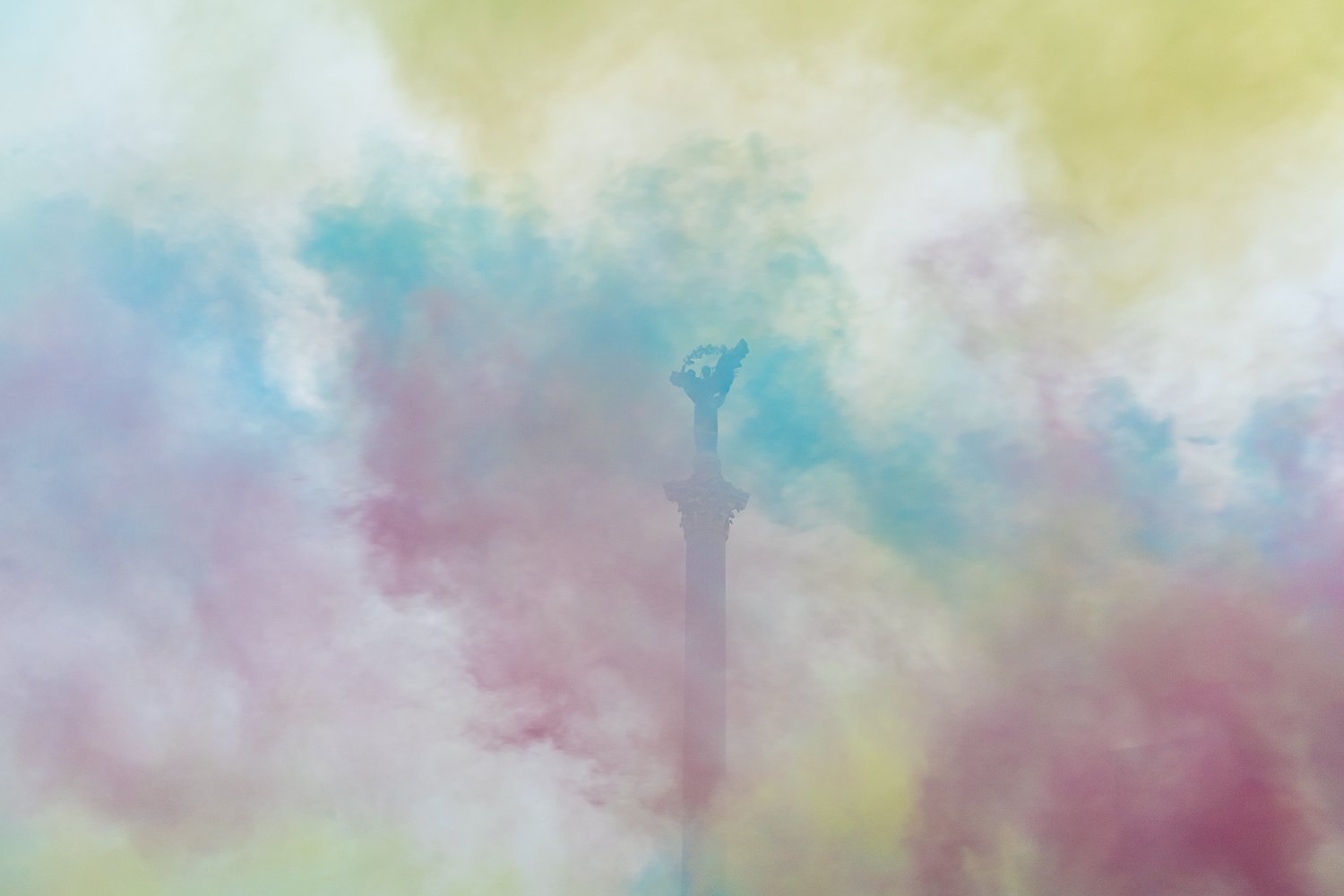  Colored smoke from signal flares obscures the independence monument in the center of Maidan Nezalezhnosti, or Independence Square, during a rally and march held by family members and other supporters of Ukrainian soldiers and civilians being held pr