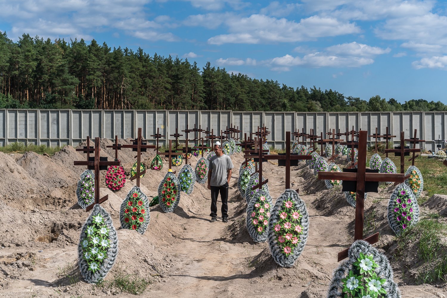  A cemetery worker stands amid the graves of unidentified civilian victims of the Russian invasion and occupation discovered nearby at the Bucha City Cemetery on Friday, September 2, 2022 in Bucha, Ukraine. 