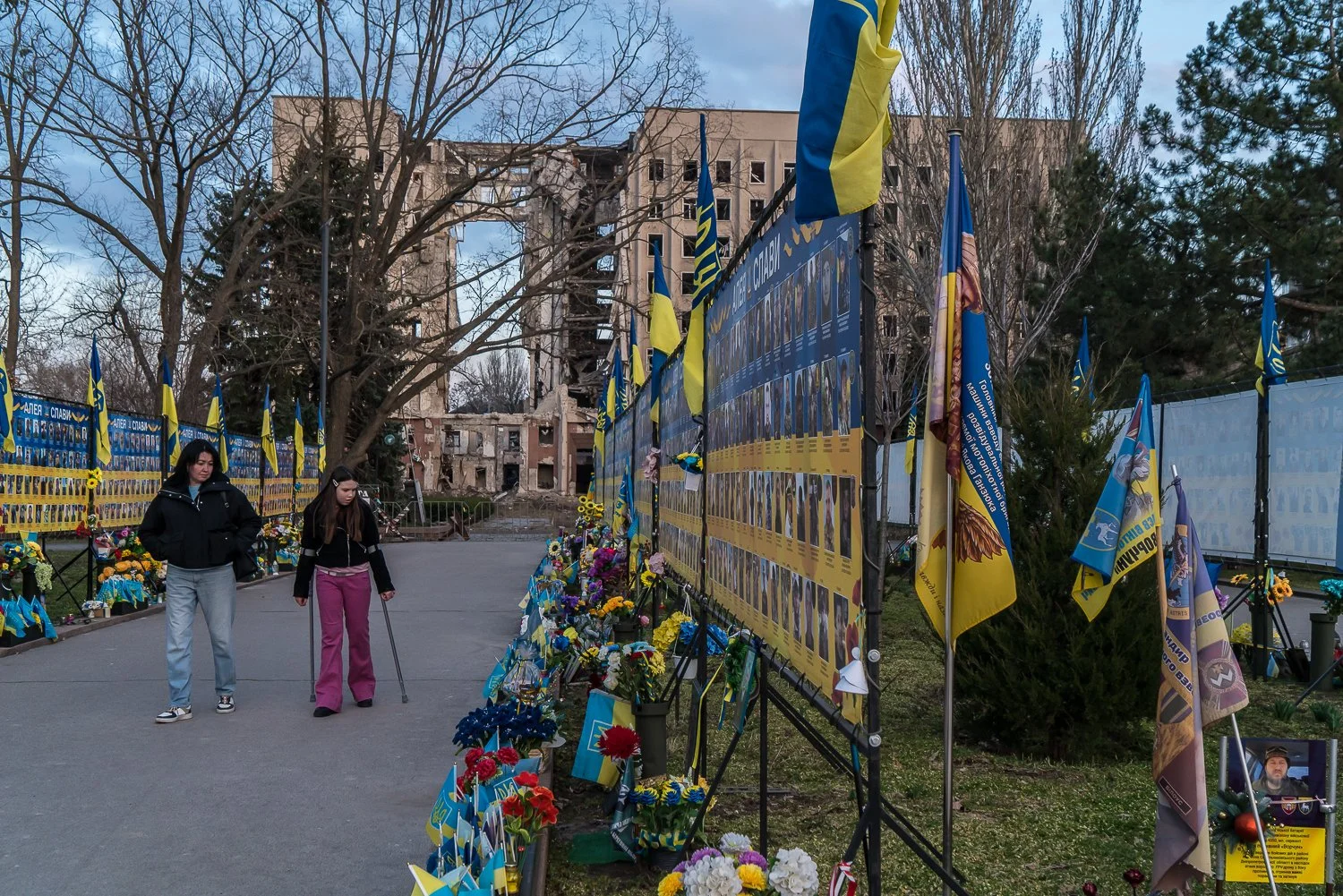  People look at a commemorative display in honor of Ukrainian soldiers who have died in the war with Russia near the Mykolaiv Regional Administration building, which was destroyed by a Russian missile in March 2022, on Thursday, March 19, 2026 in Myk