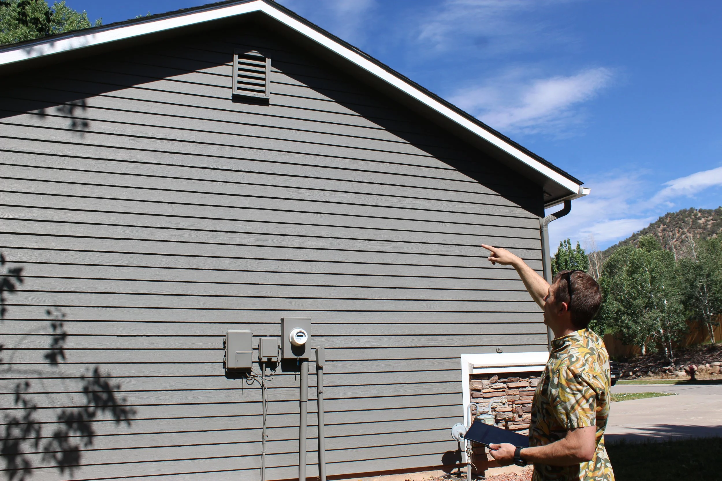  Sam Feuerborn identifying vulnerable areas along the roofline and utility connections. 